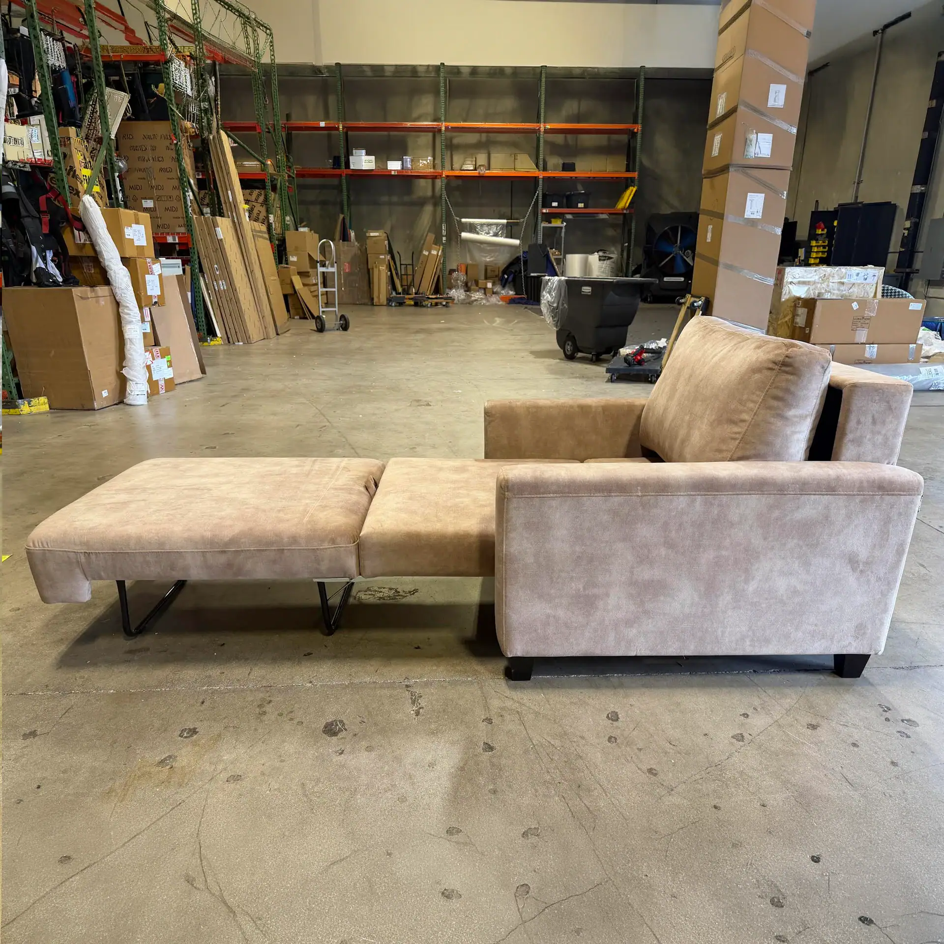 Comfortable Luonto Nico Cot Size Sleeper Chair in warehouse setting.
