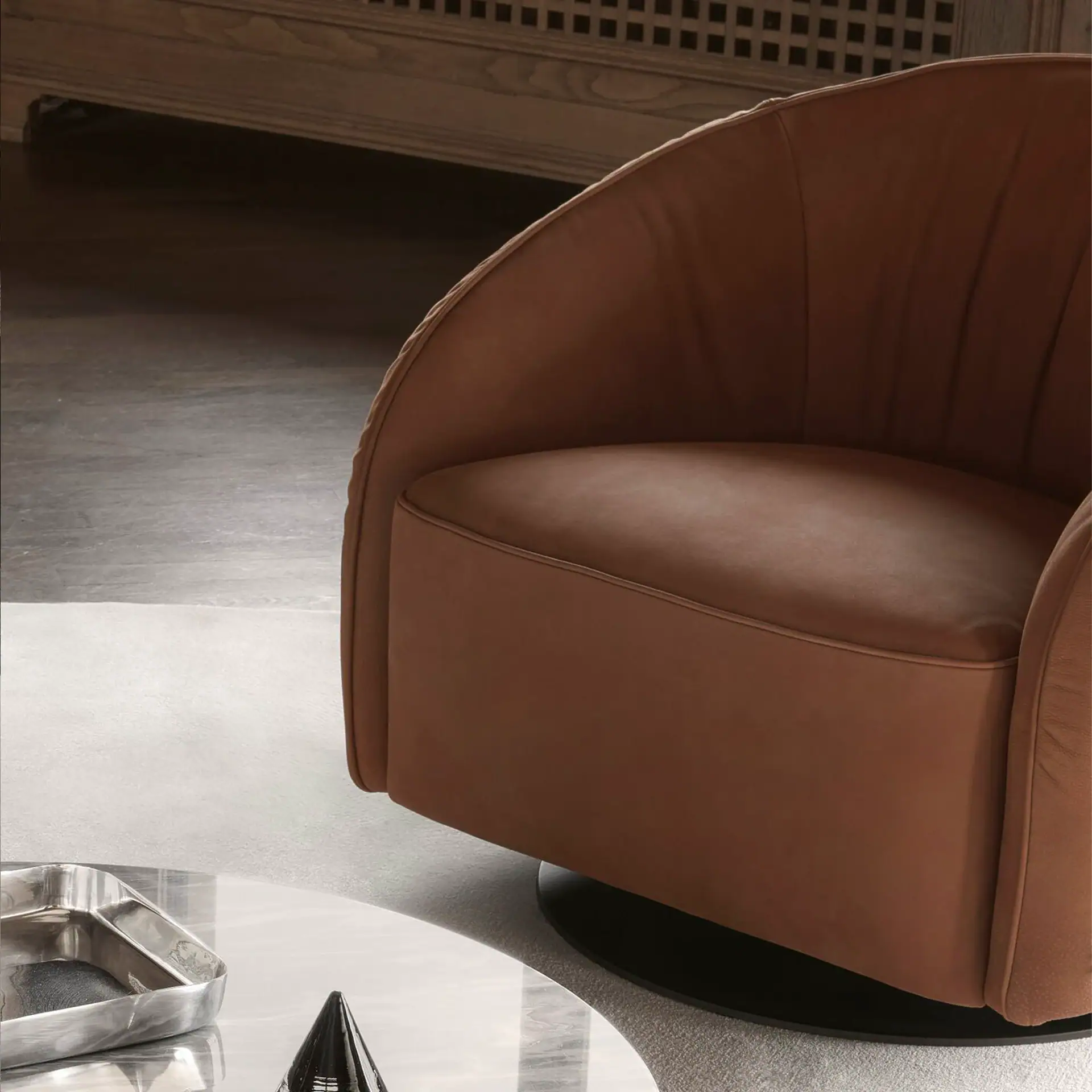 Modern Nest Swivel Armchair in warm brown leather for stylish living spaces.