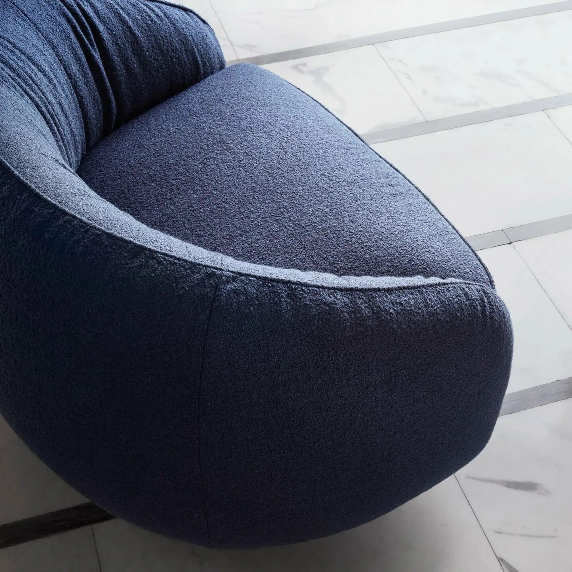 Modern navy blue Nest swivel armchair with plush fabric upholstery.