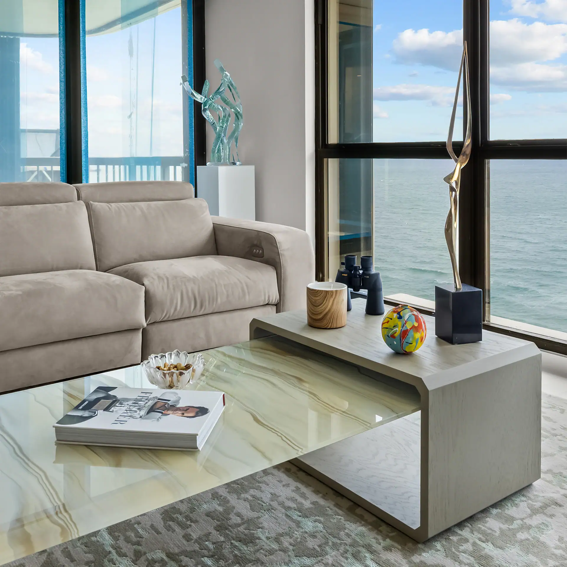 Contemporary living room with ocean view, beige sofa, and modern decor.