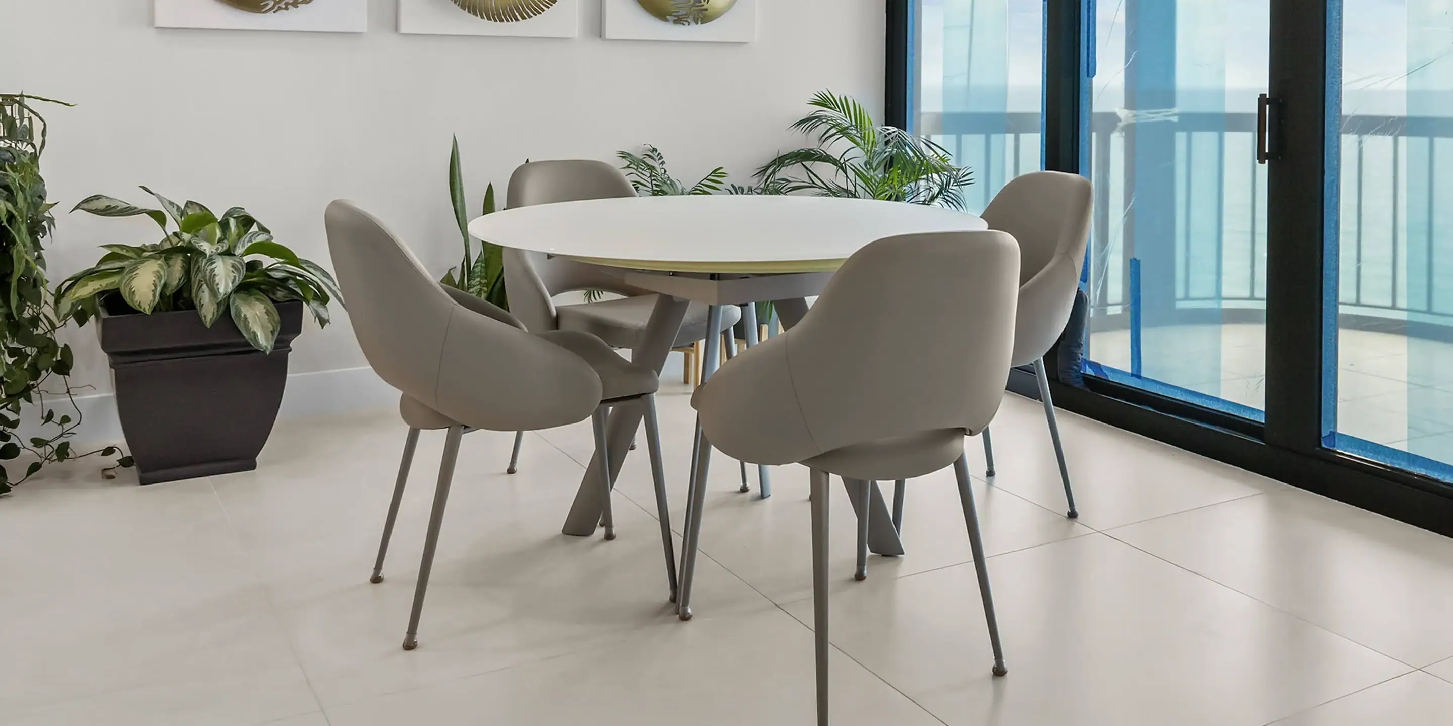 ocean-views-thoughtful-design-case-study-6.6 Modern round dining table with six upholstered chairs in a bright, contemporary interior.