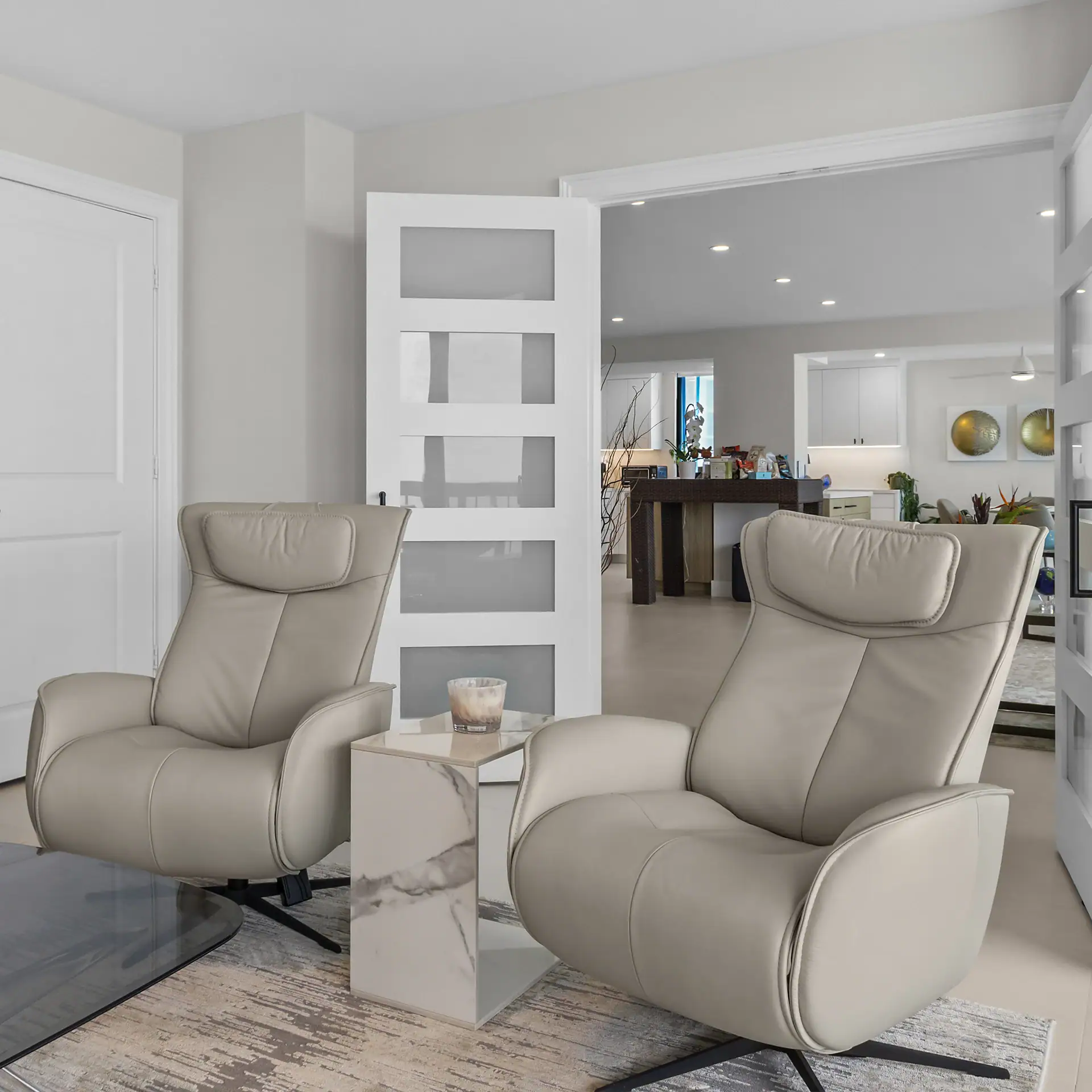 Beige leather armchairs with a marble side table in a modern, bright living room setting.