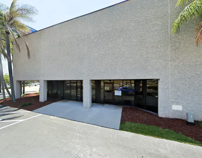 Commercial building with large glass windows and textured exterior wall.