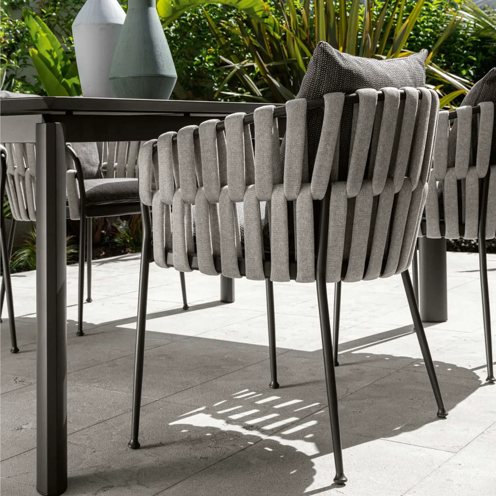 Outdoor dining armchair with modern design and plush cushions. Perfect for stylish outdoor patio or.