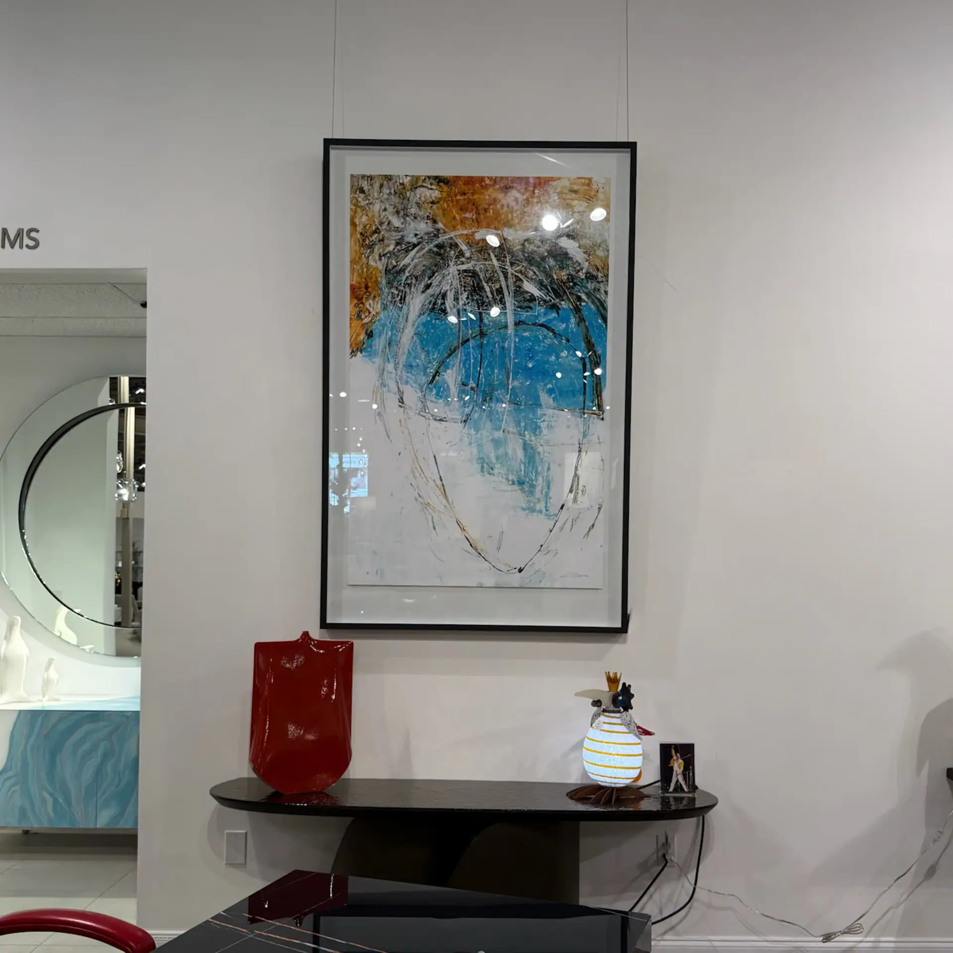 Abstract art painting with vibrant blue, gold, and black colors in a black frame.