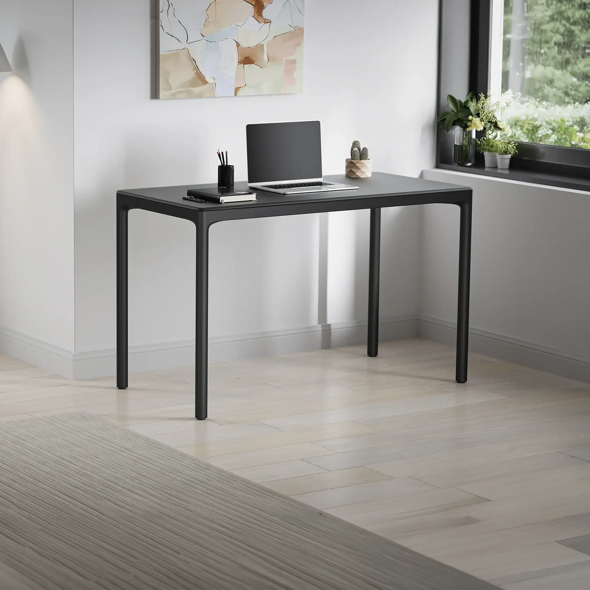 A modern black desk with a laptop, pen holder, notebook, and cactus, set against a white wall with an abstract painting. A large window with plants overlooks greenery, and a light wooden floor with a gray rug completes the scene.