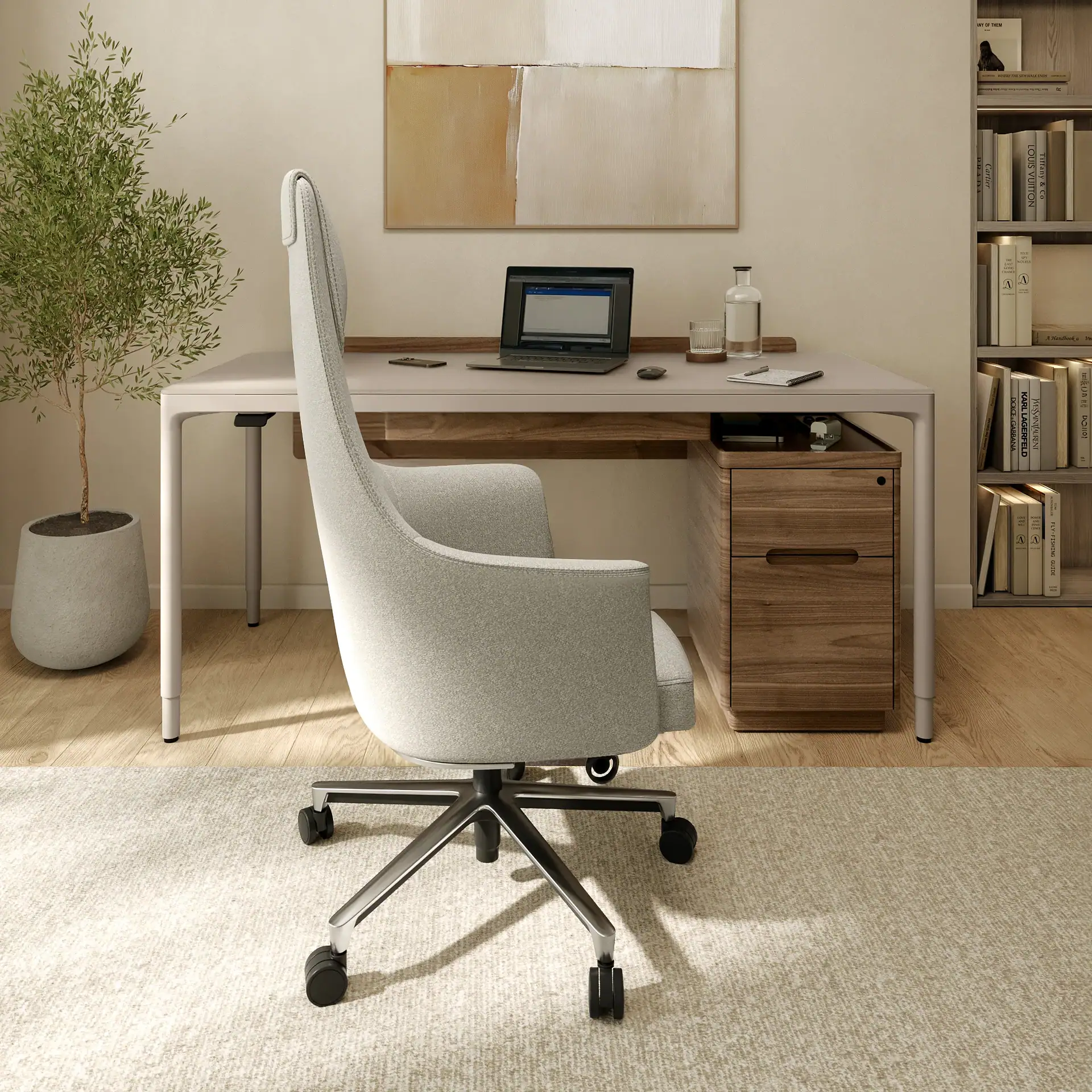 A modern home office with a light grey desk, chair, laptop, and a wooden filing cabinet. A potted plant and a bookshelf with books are also visible.
