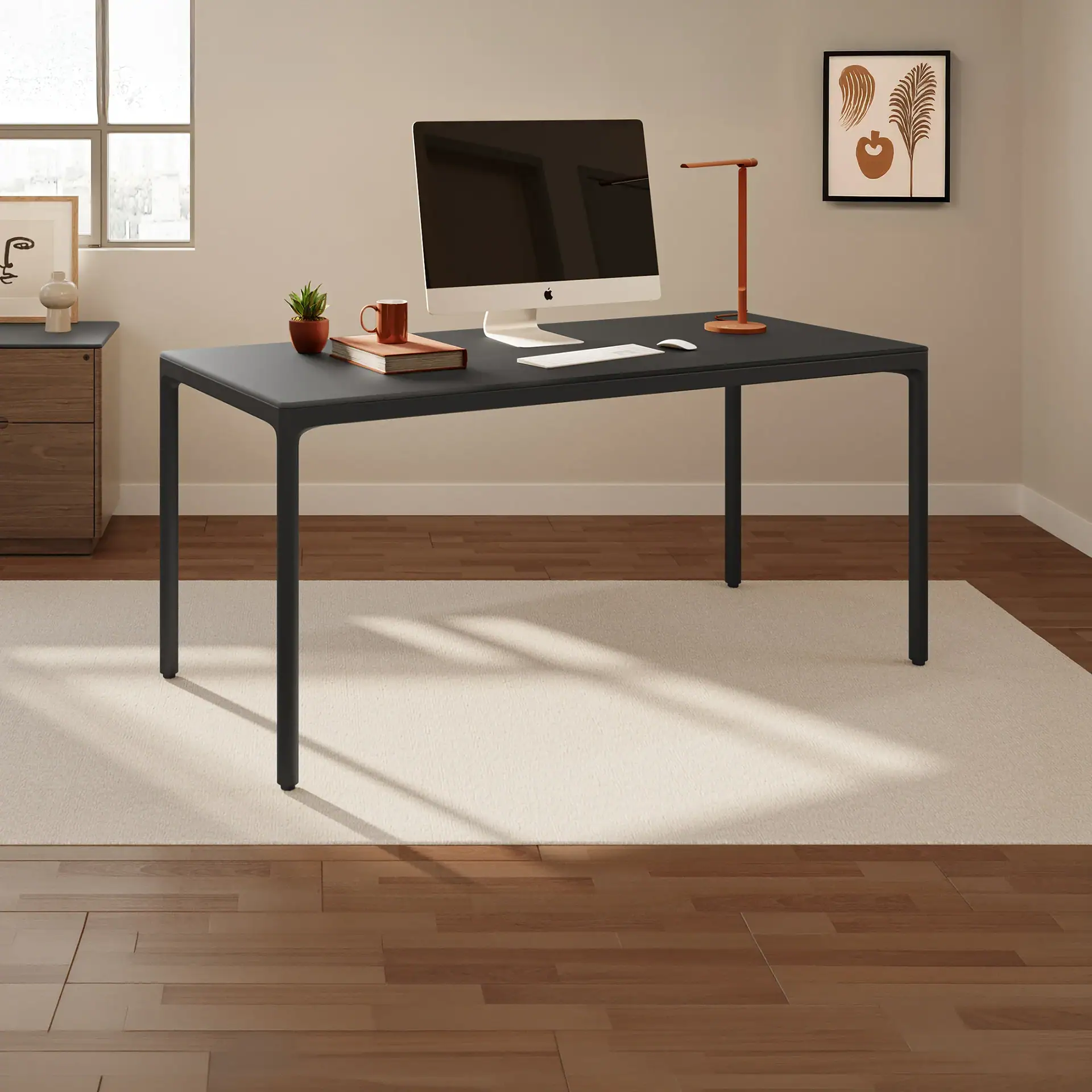 A modern home office with a dark gray desk, iMac computer, orange desk lamp, and minimalist decor on a beige rug and hardwood floor.