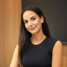 Woman with long dark hair in a black sleeveless top at Sklar Furnishings.