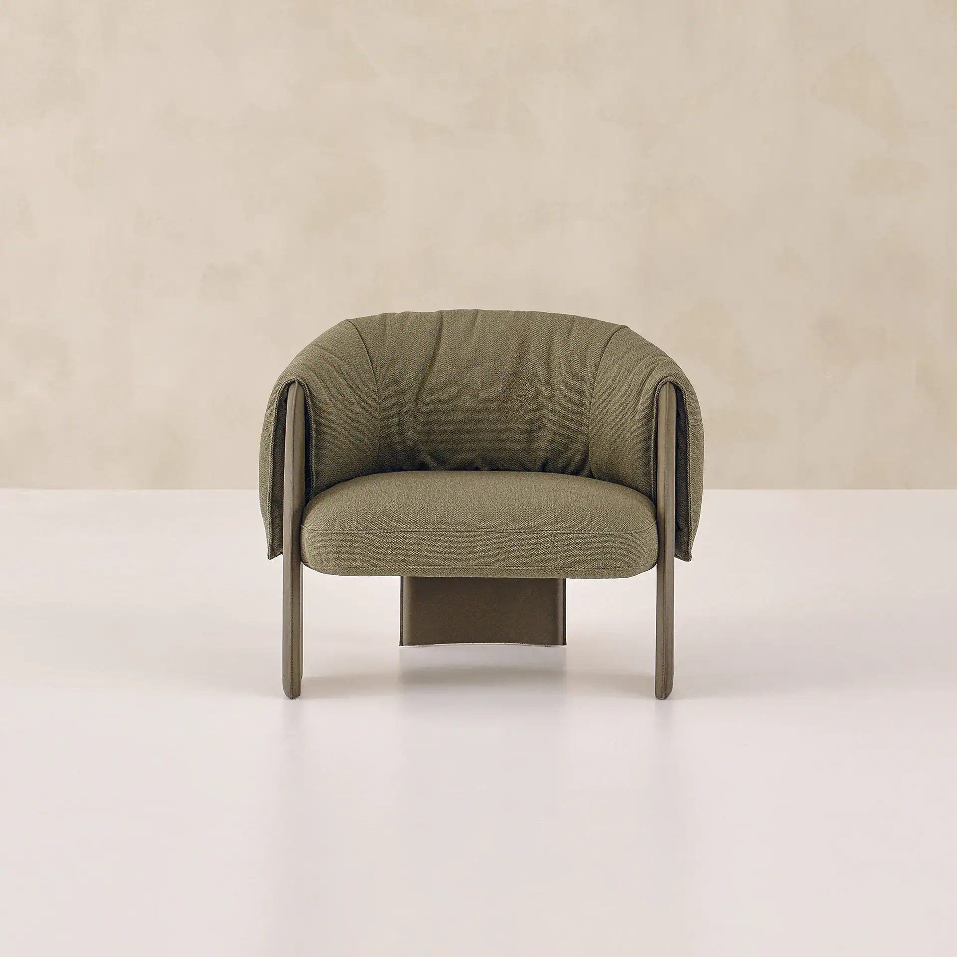 Modern olive green armchair with curved back and wooden legs.