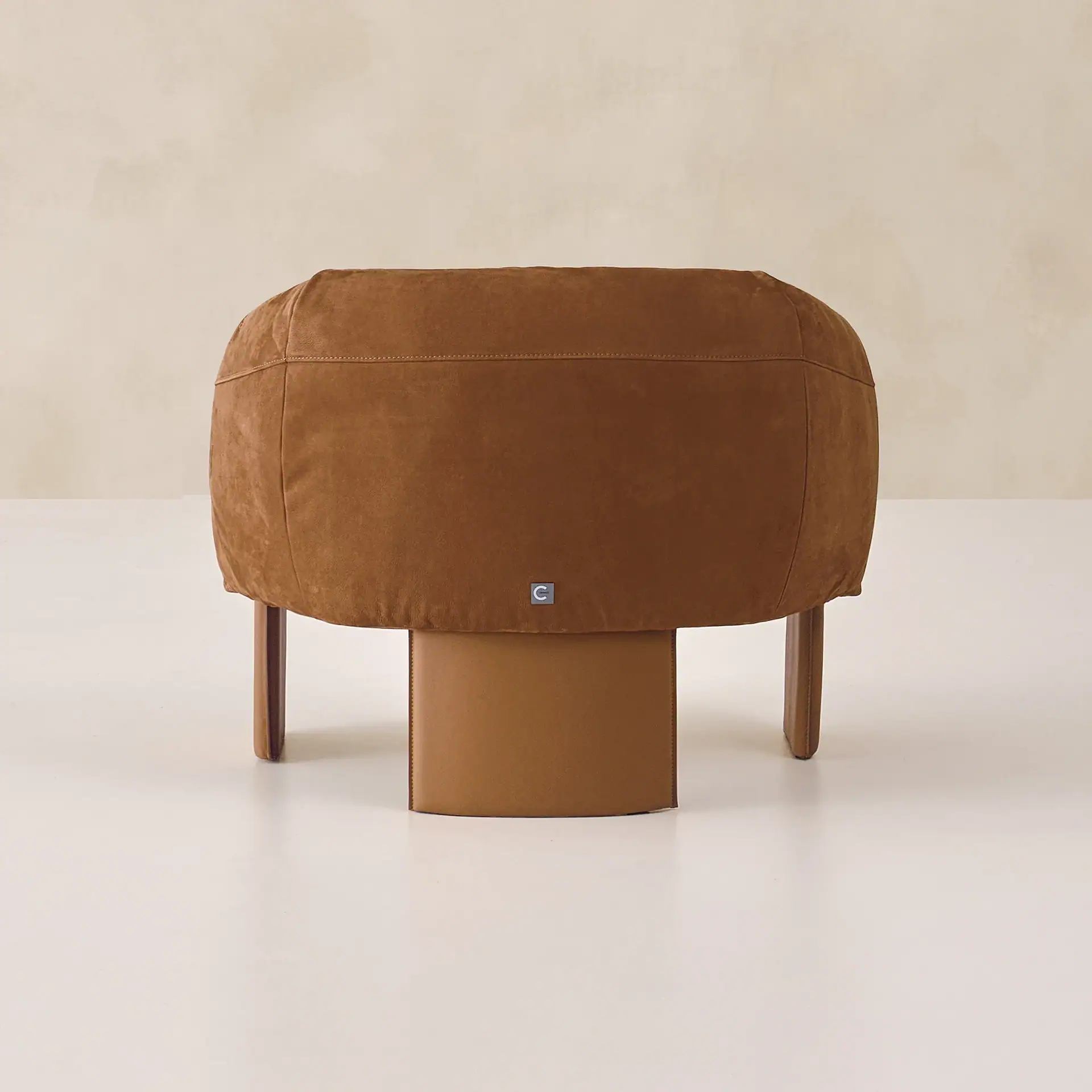 Sklar Furnishings armchair ottoman in brown suede with wooden legs.