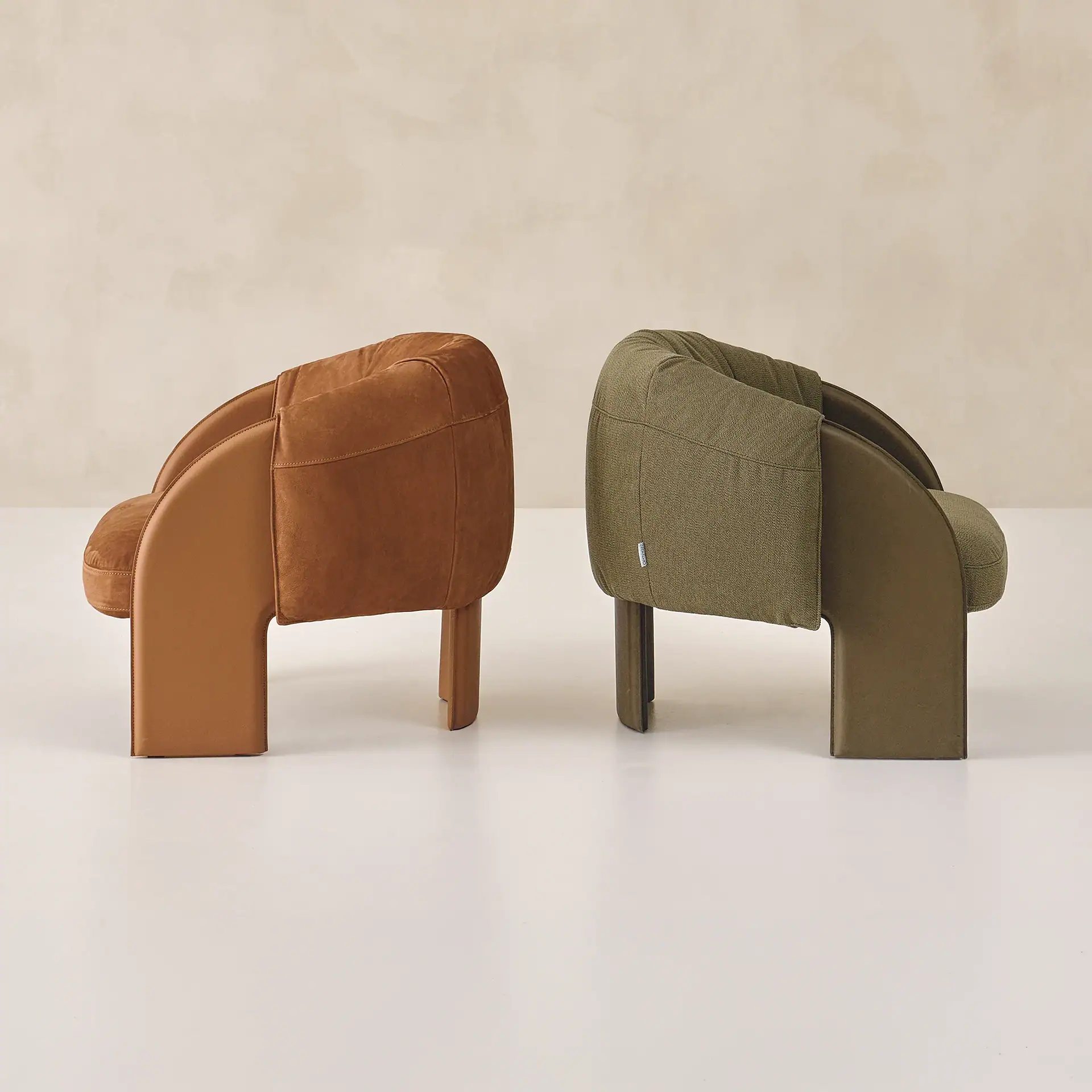 Sklar Furnishings armchairs in tan and olive green shown side by side.
