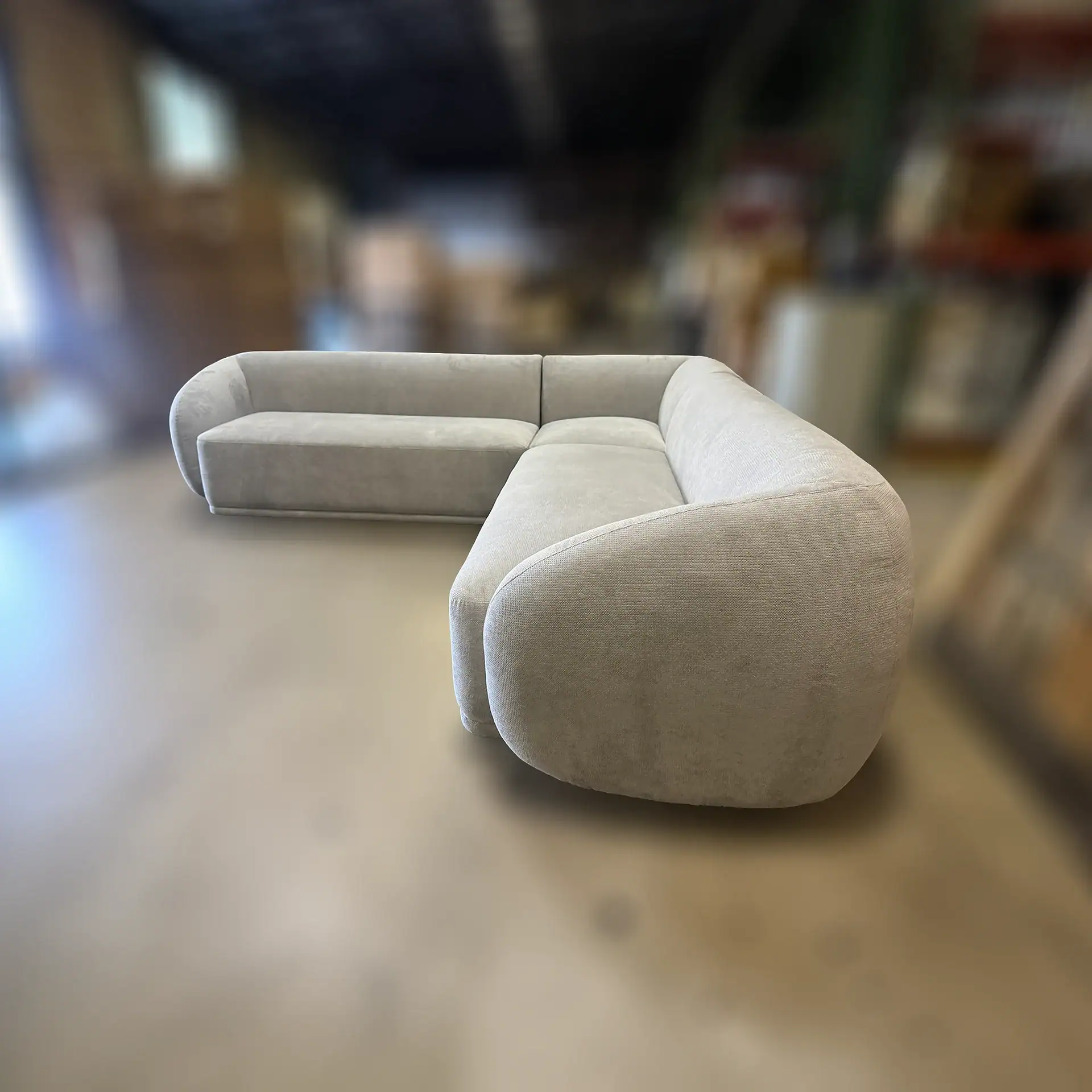 Modern beige sectional sofa with rounded arms and plush cushions.