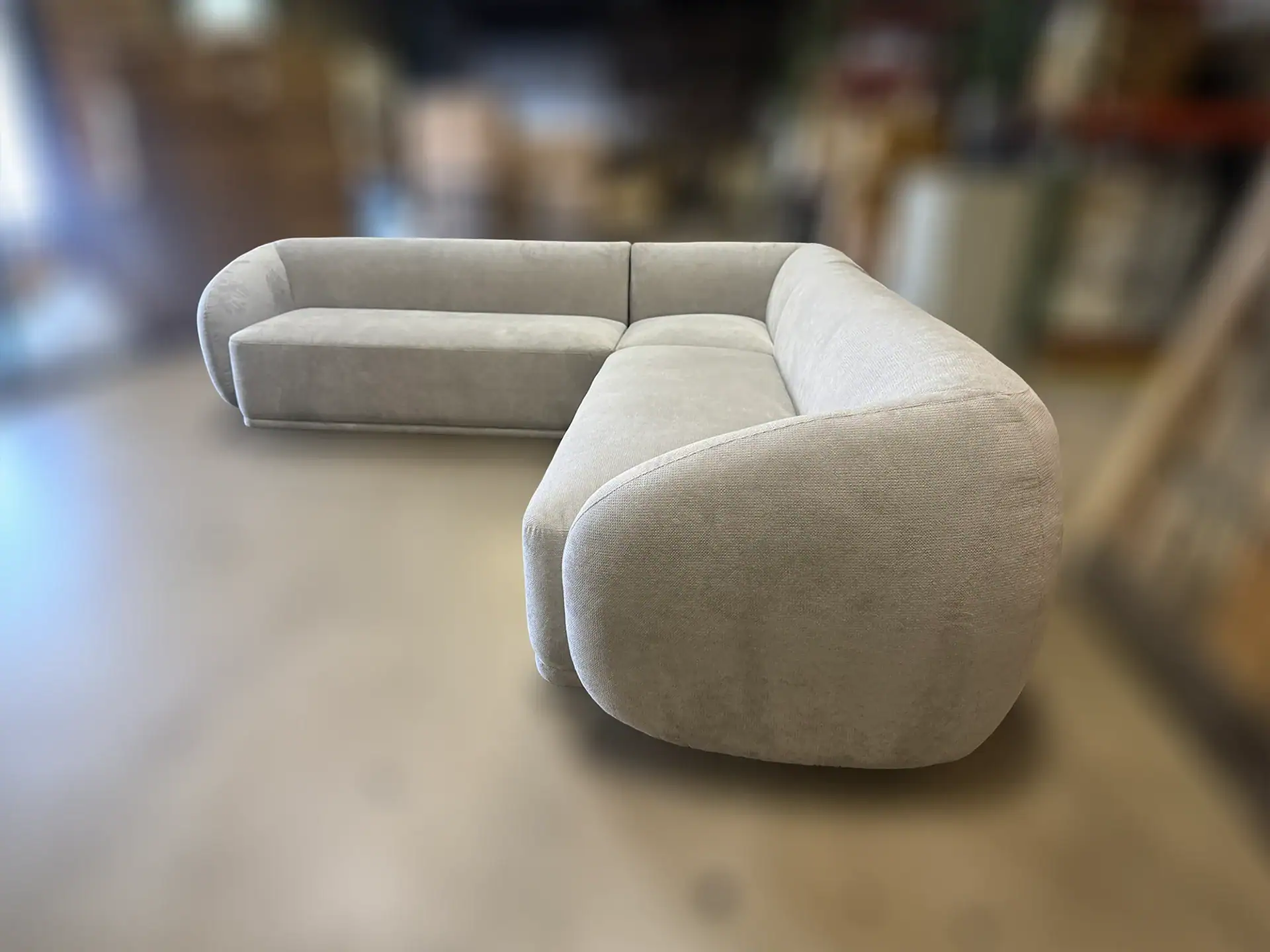 Contemporary light gray sectional sofa with rounded arms and plush cushions.