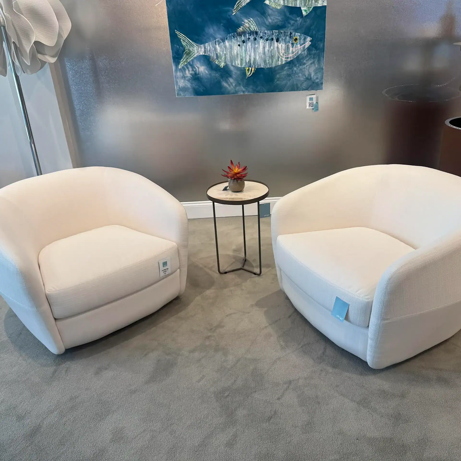 Contemporary white lounge chairs in a stylish showroom setting.