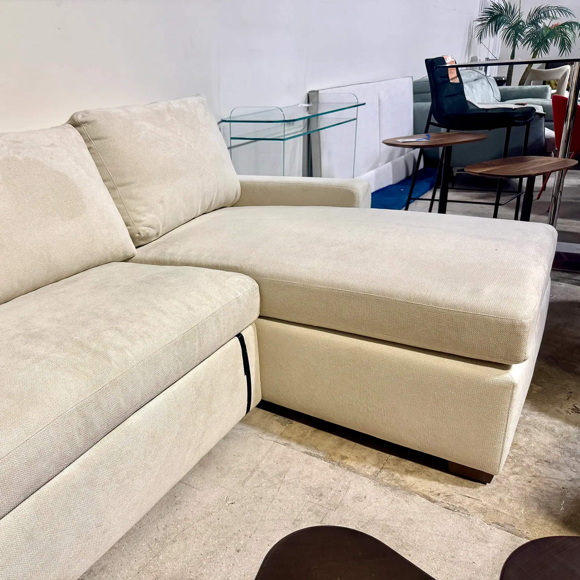 Cream-colored leather sleeper sofa in modern living room setting.