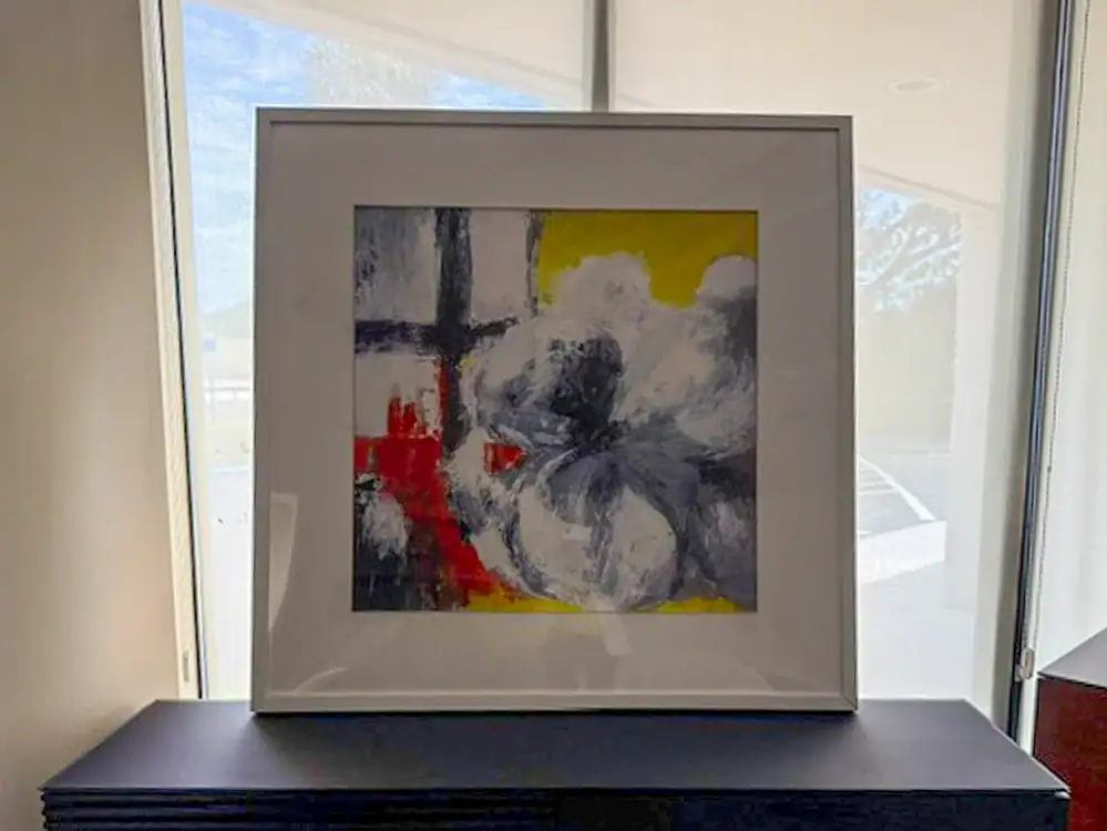 Colorful abstract wall art with yellow, red, black, and gray tones in a white frame.