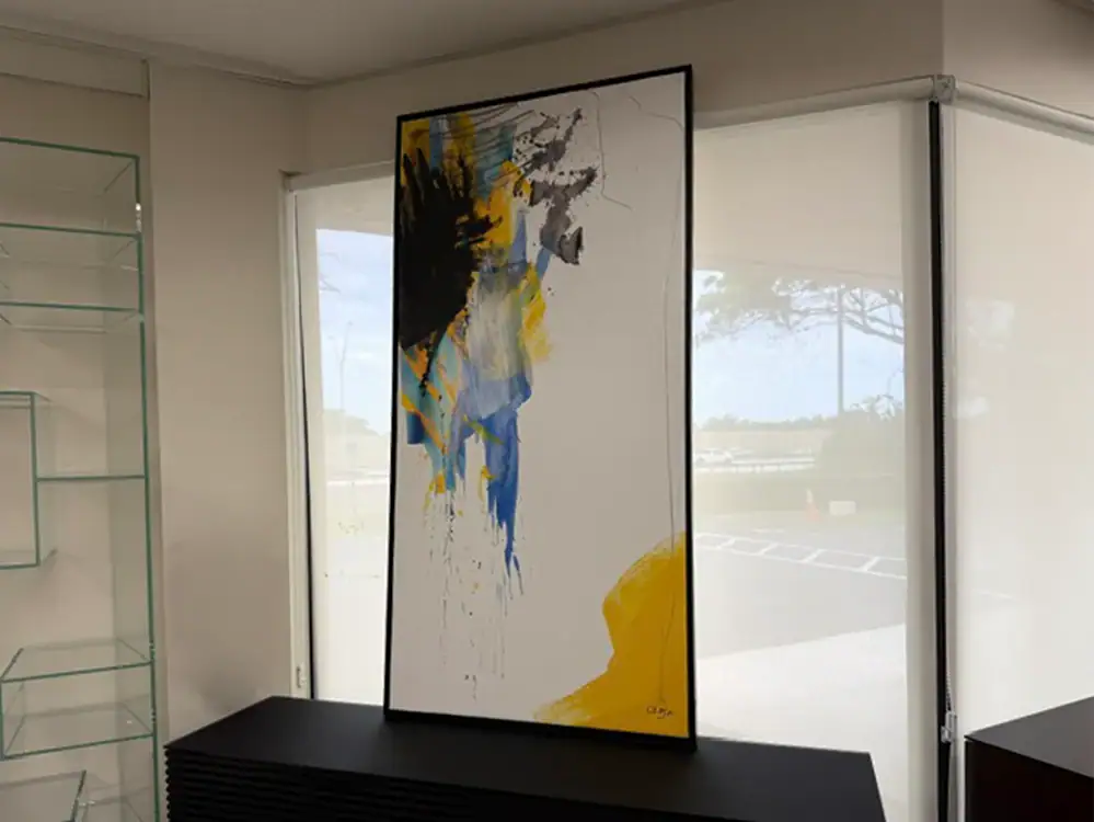 Abstract wall art with black, yellow, blue, and gray paint splashes.