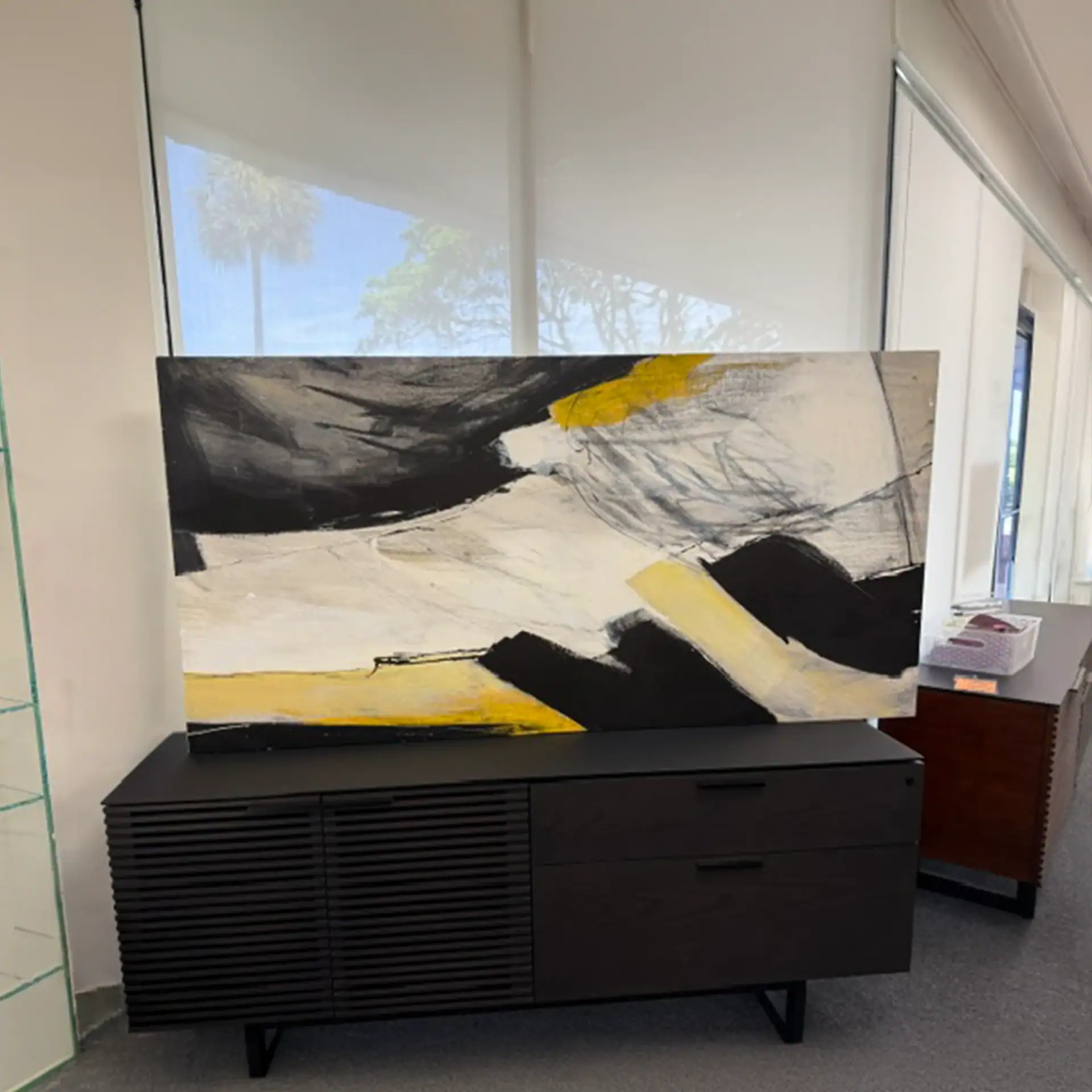 Abstract black, white, and yellow wall art in a contemporary living space.