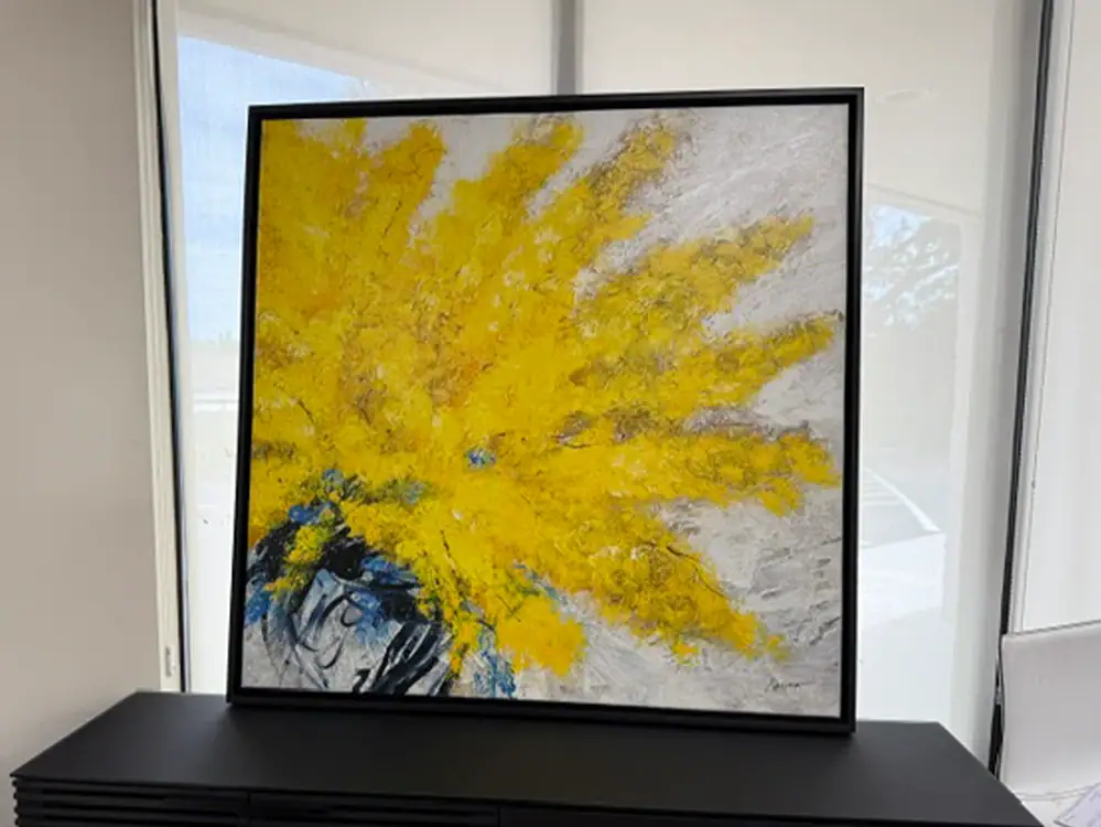 Colorful abstract whirlwind wall art with yellow and gray tones.