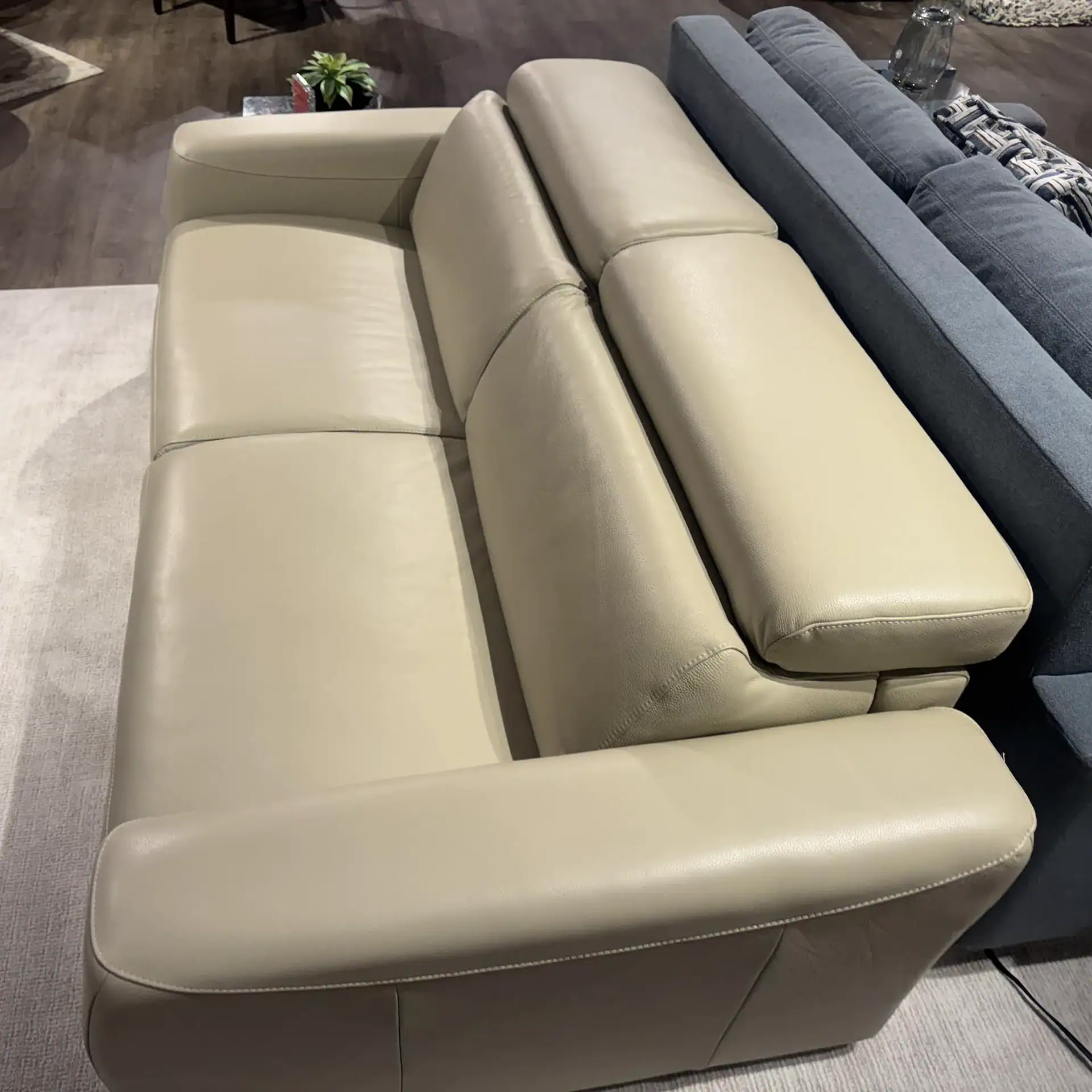 Beige leather sofa with plush cushions, perfect for contemporary living room decor.