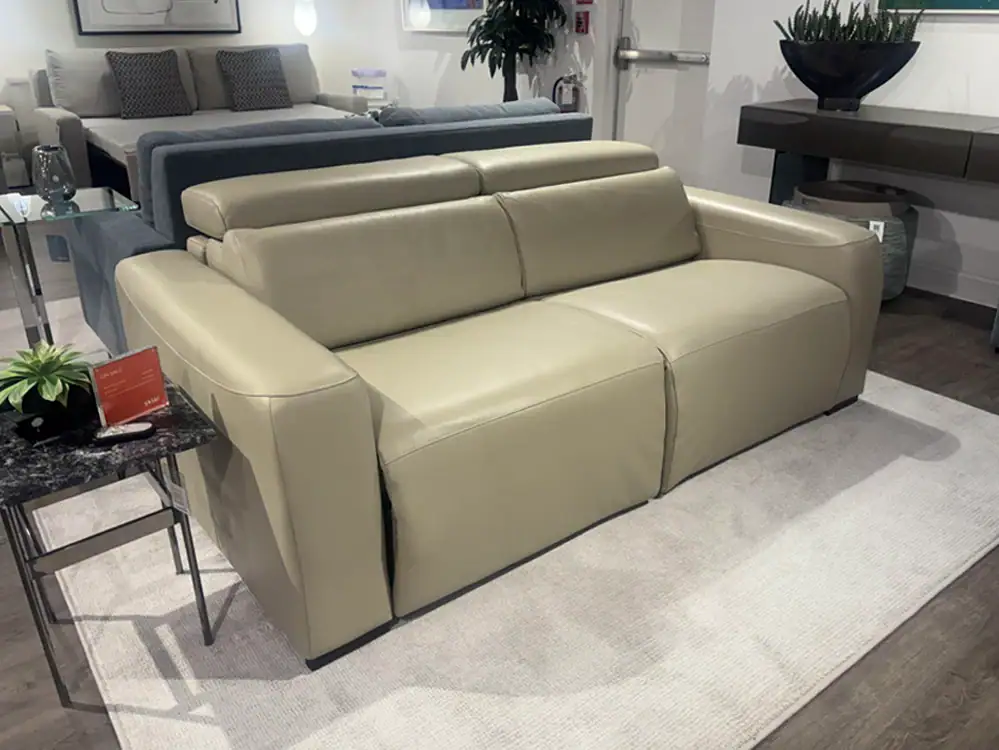 Beige leather sofa with sleek design, perfect for contemporary living room decor. Comfortable seatin.