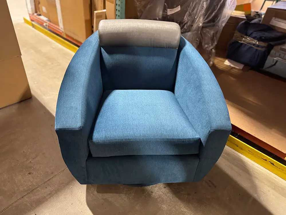 Modern blue swivel glider chair with gray headrest for living room.