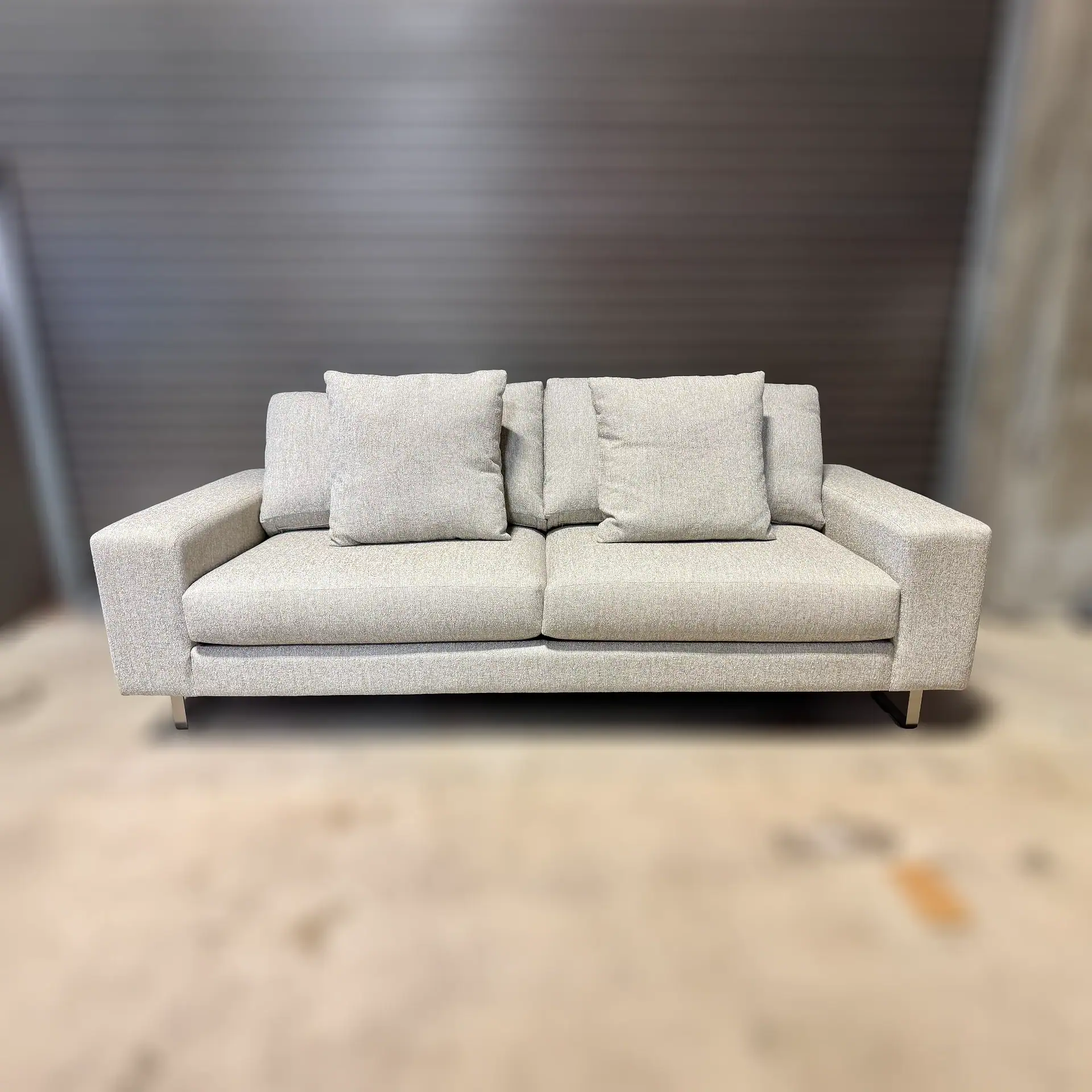 Modern beige sofa with cushions in a contemporary living room setting.