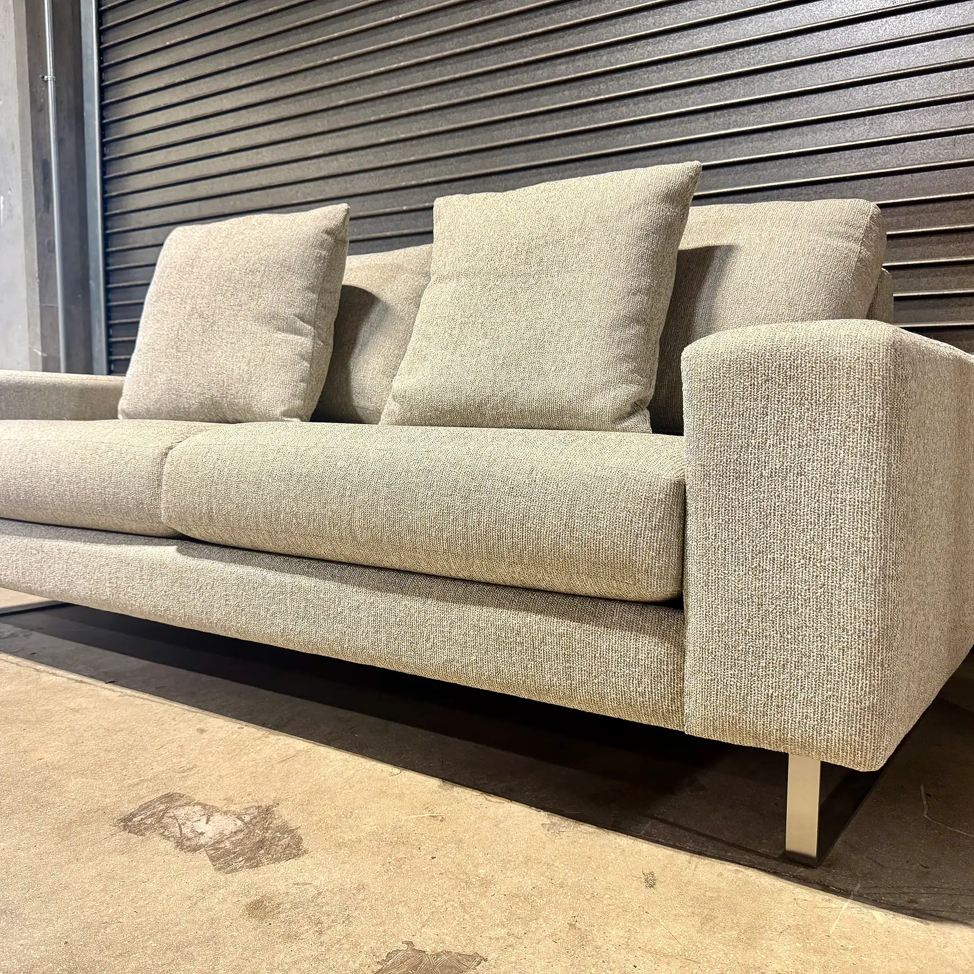 Modern beige sofa with cushions from Sklar Furnishings in a showroom.
