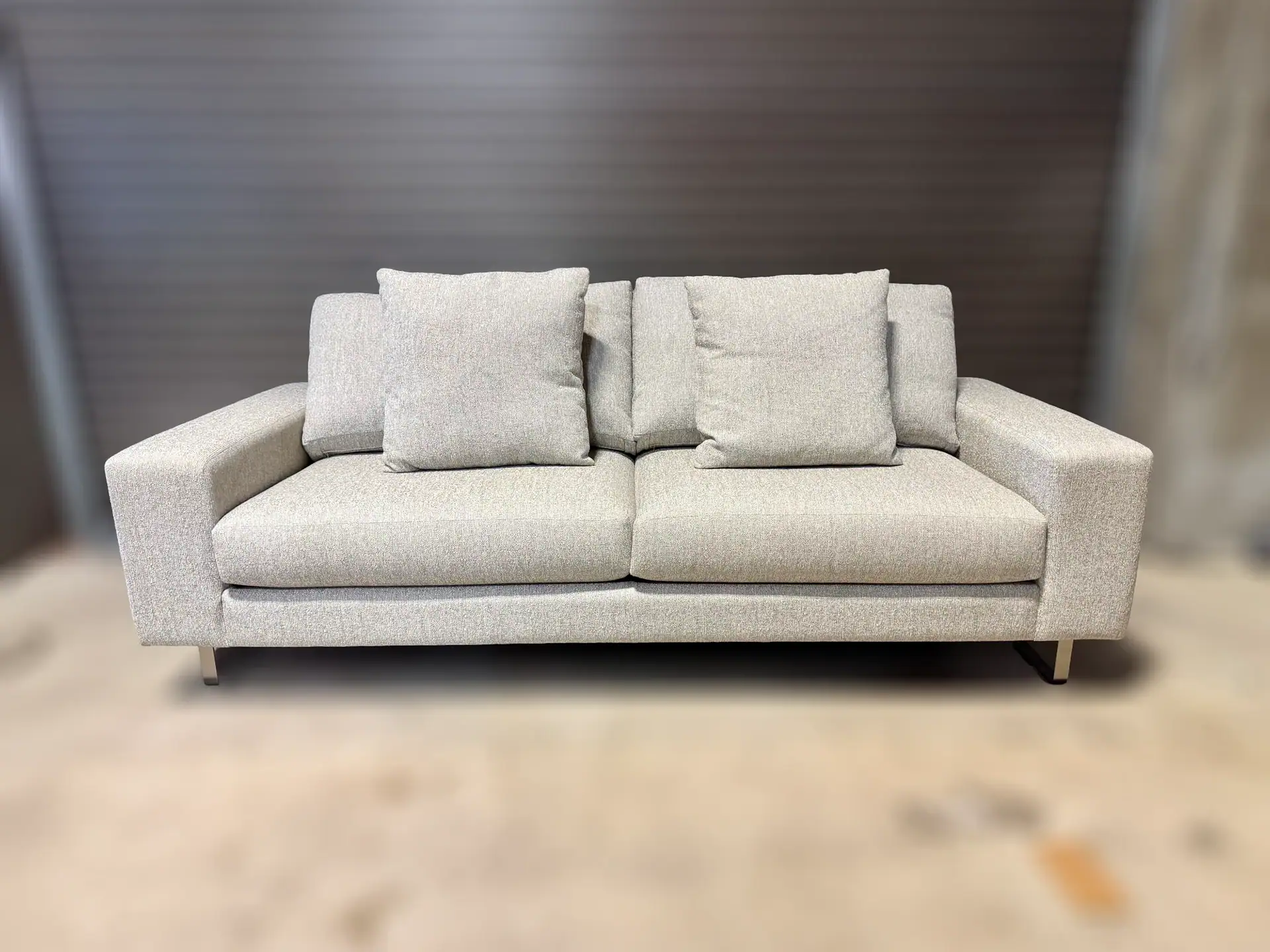 Modern beige sofa with cushions in a contemporary living room setting.