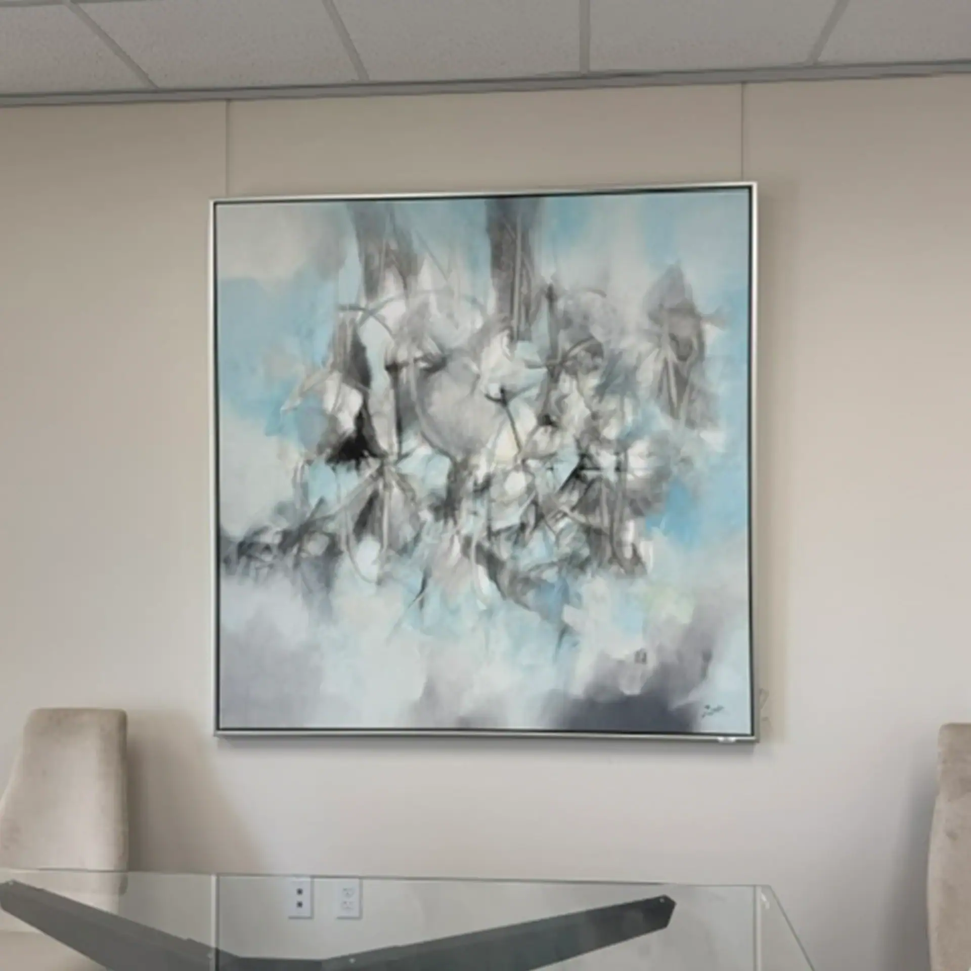 Abstract blue and white wall art in a contemporary office setting.