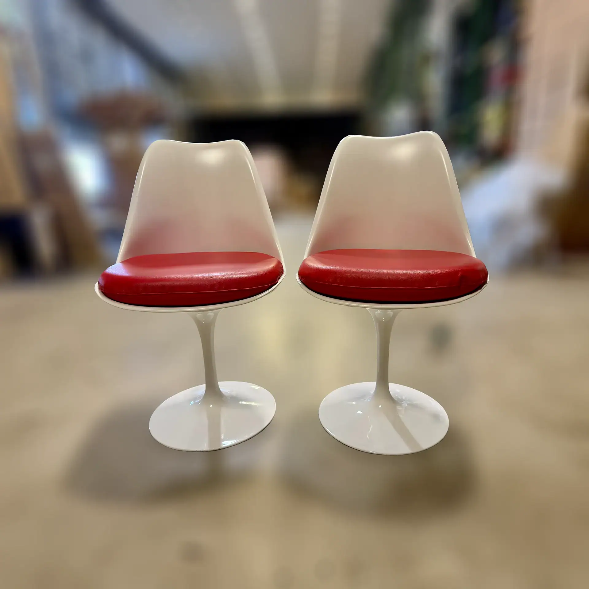 Pair of Matrix Armless Tulip Dining Chairs with red seats and white bases.