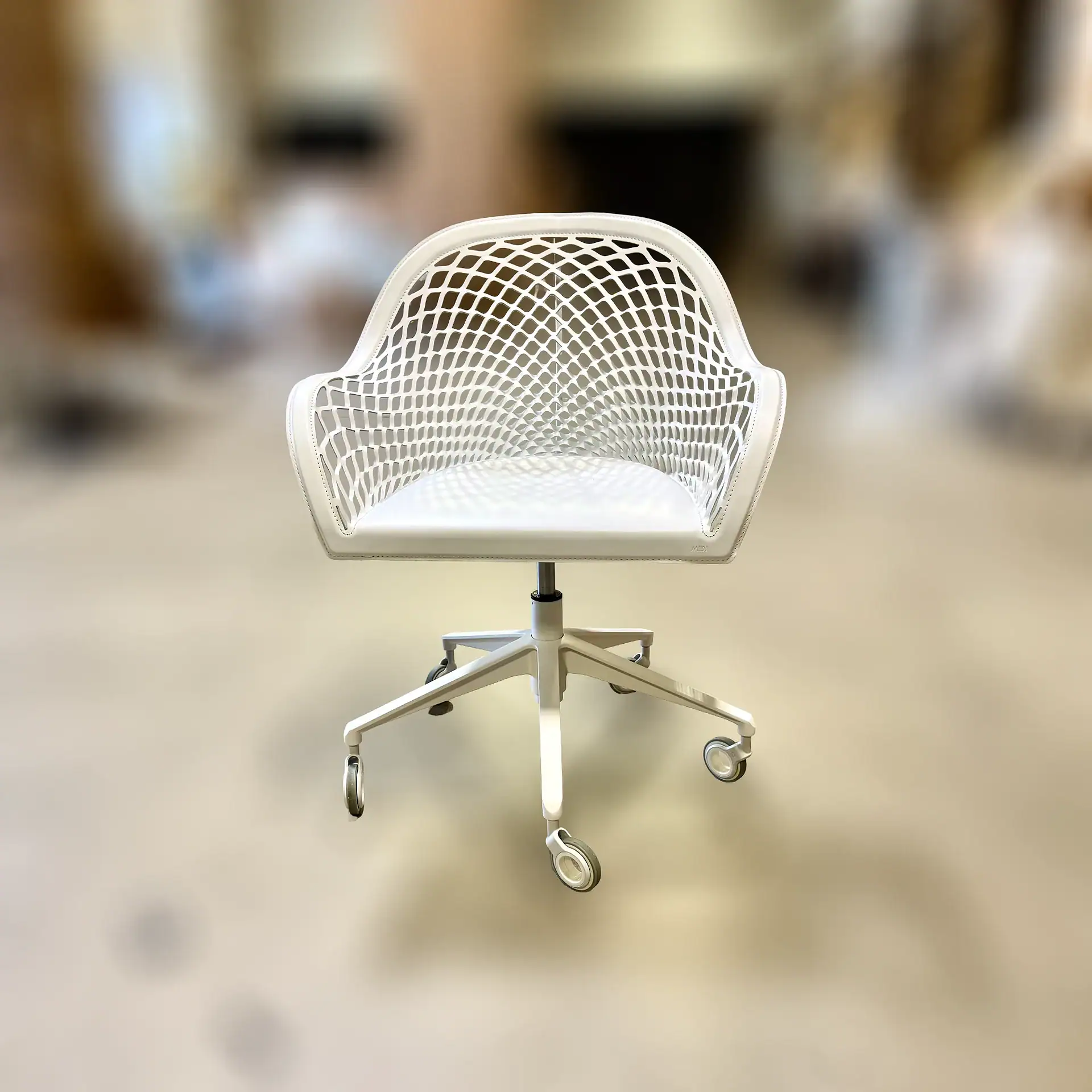 Modern white office armchair with a mesh back and caster wheels.