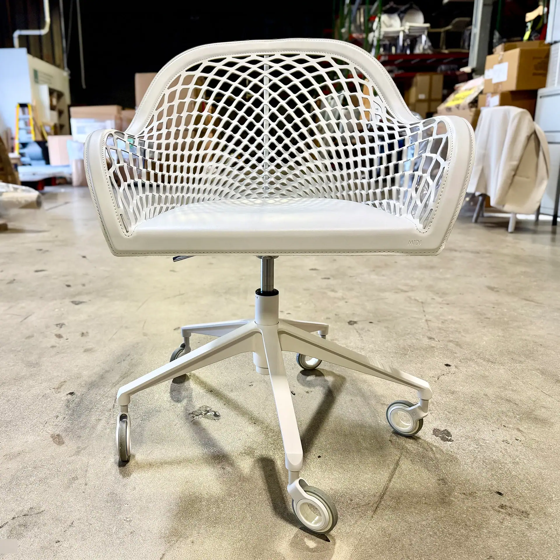 Modern white office chair with a lattice backrest and caster wheels.