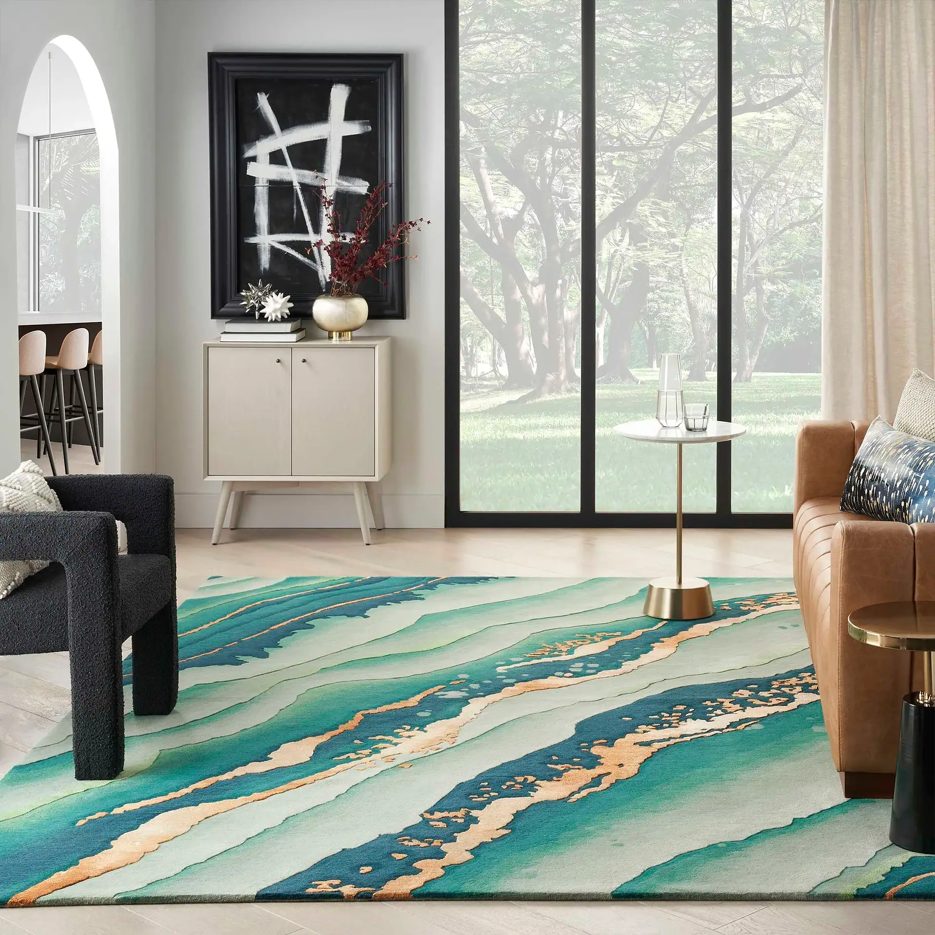 Modern living room with colorful abstract area rug and large window view.
