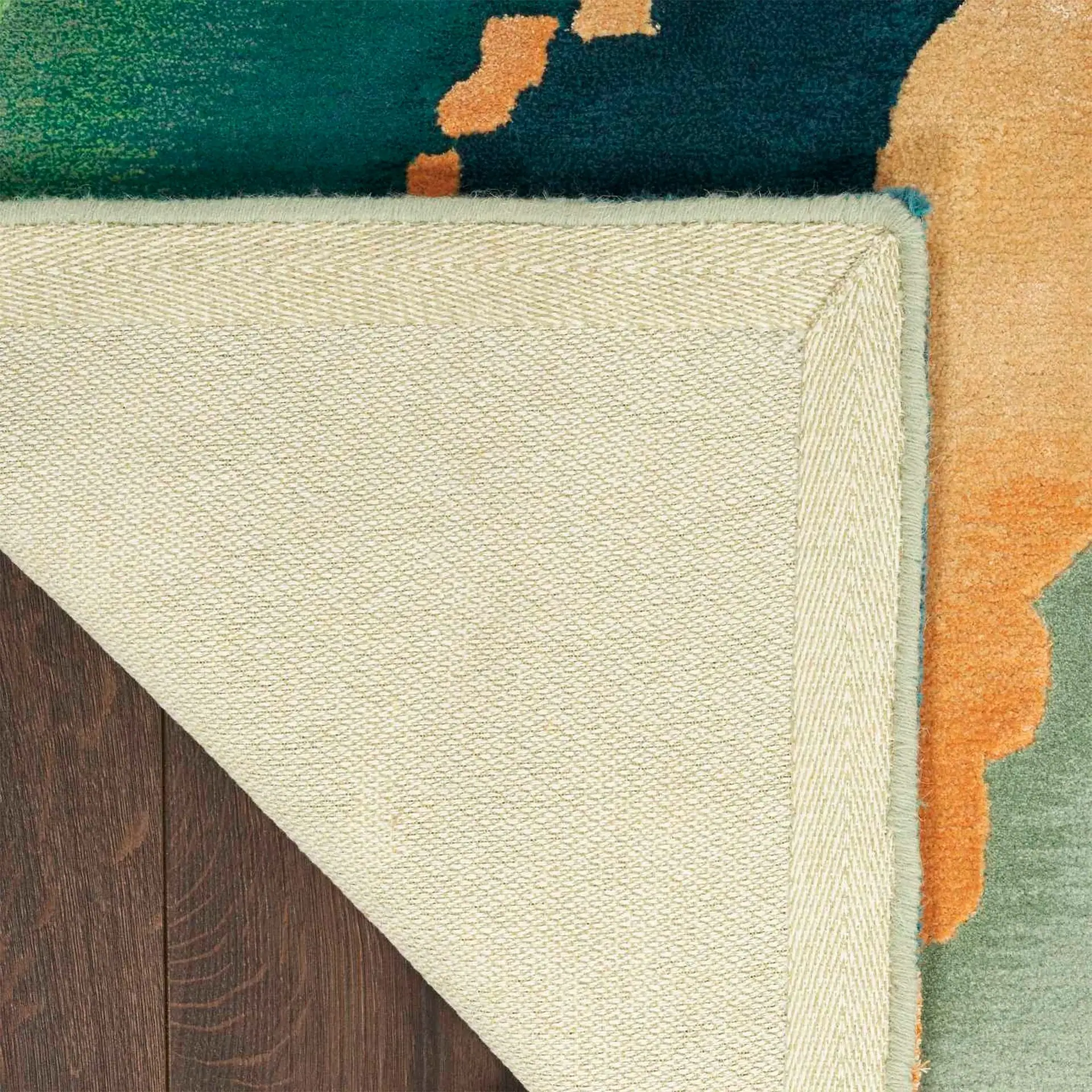 Close-up of a corner of a cream-colored rug with a textured weave and a decorative border.