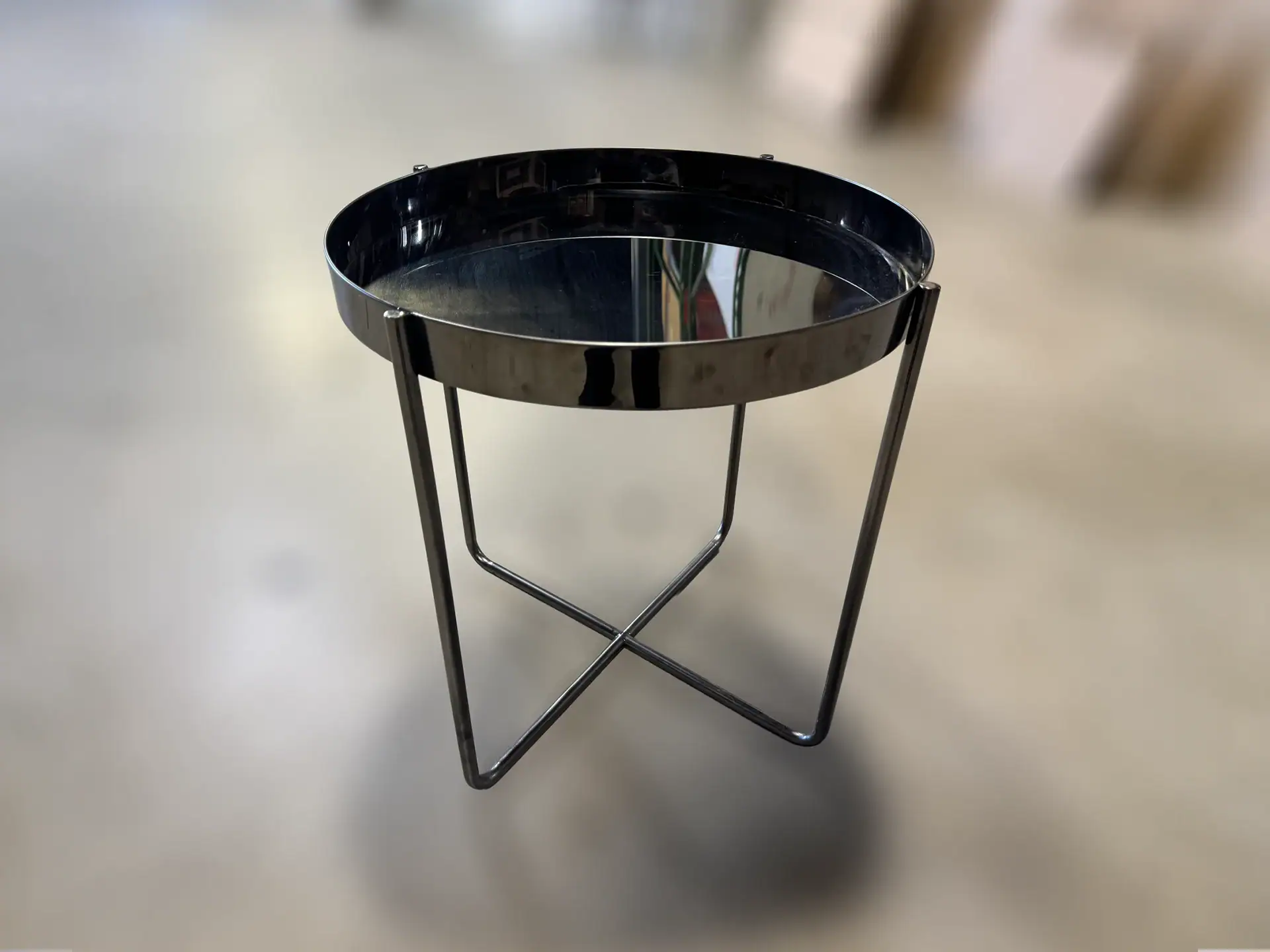 Modern black side table with metal frame and glass top.