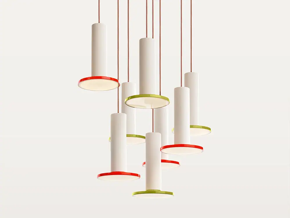 Contemporary pendant lights with white cylindrical shades and colorful accents.