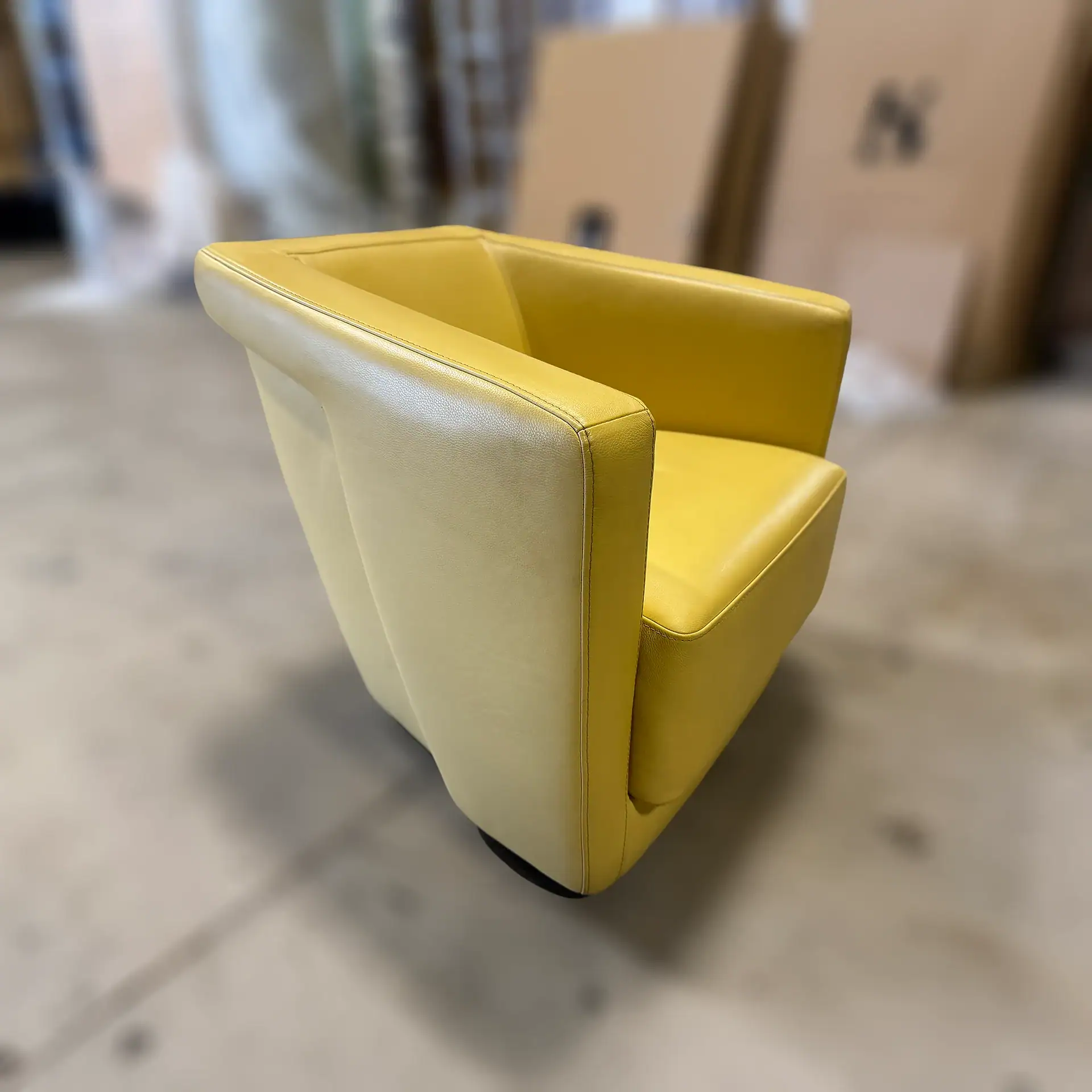 Bright yellow modern armchair with sleek design and comfortable cushioning.