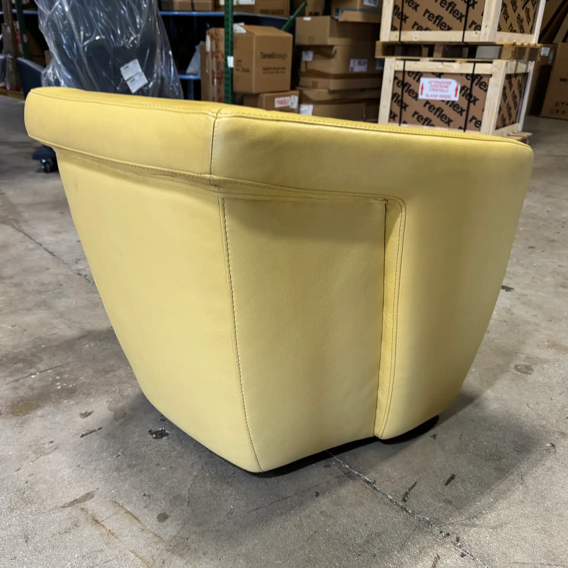 Yellow leather armchair in warehouse setting, modern furniture piece.
