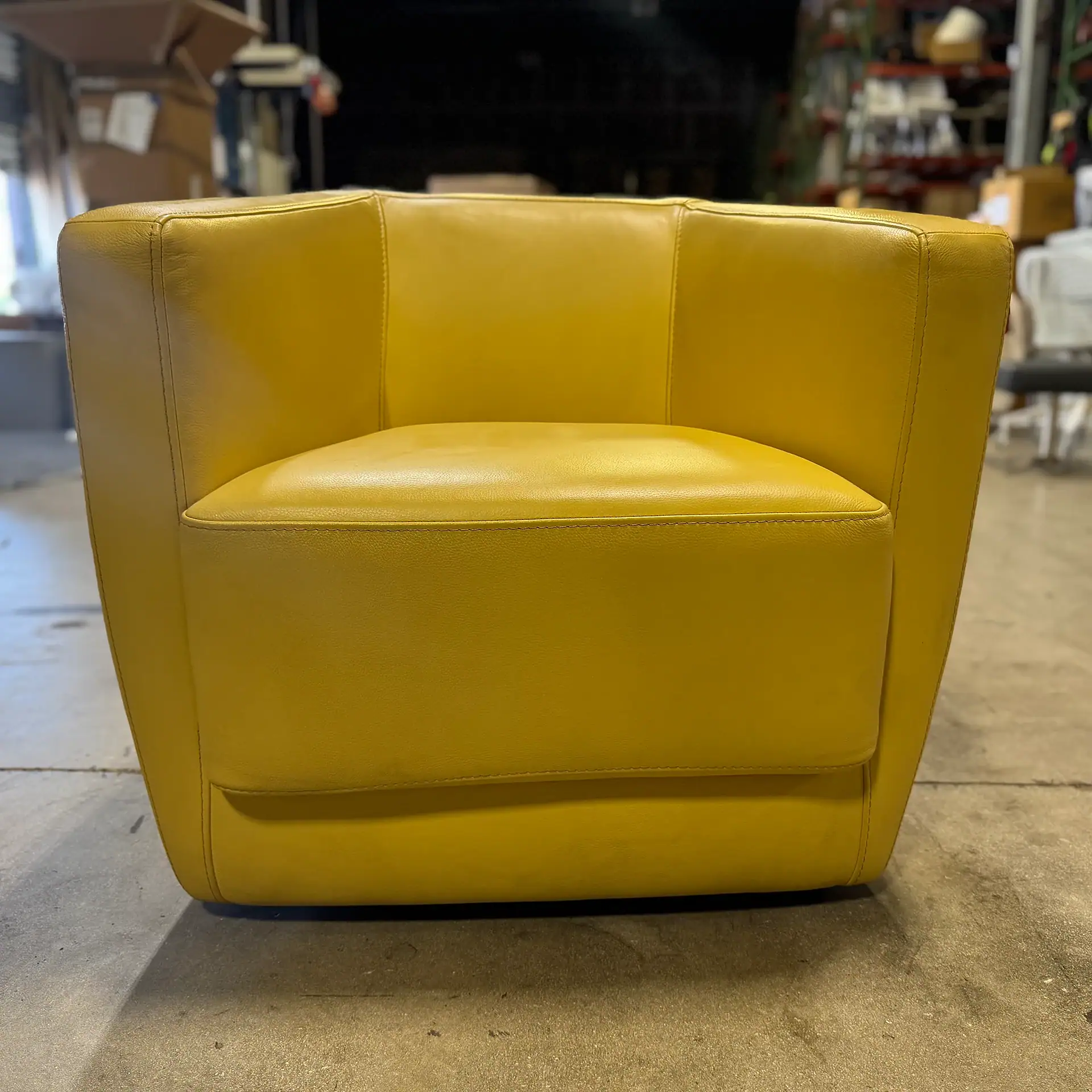Bright yellow modern armchair with sleek design and comfortable cushioning.