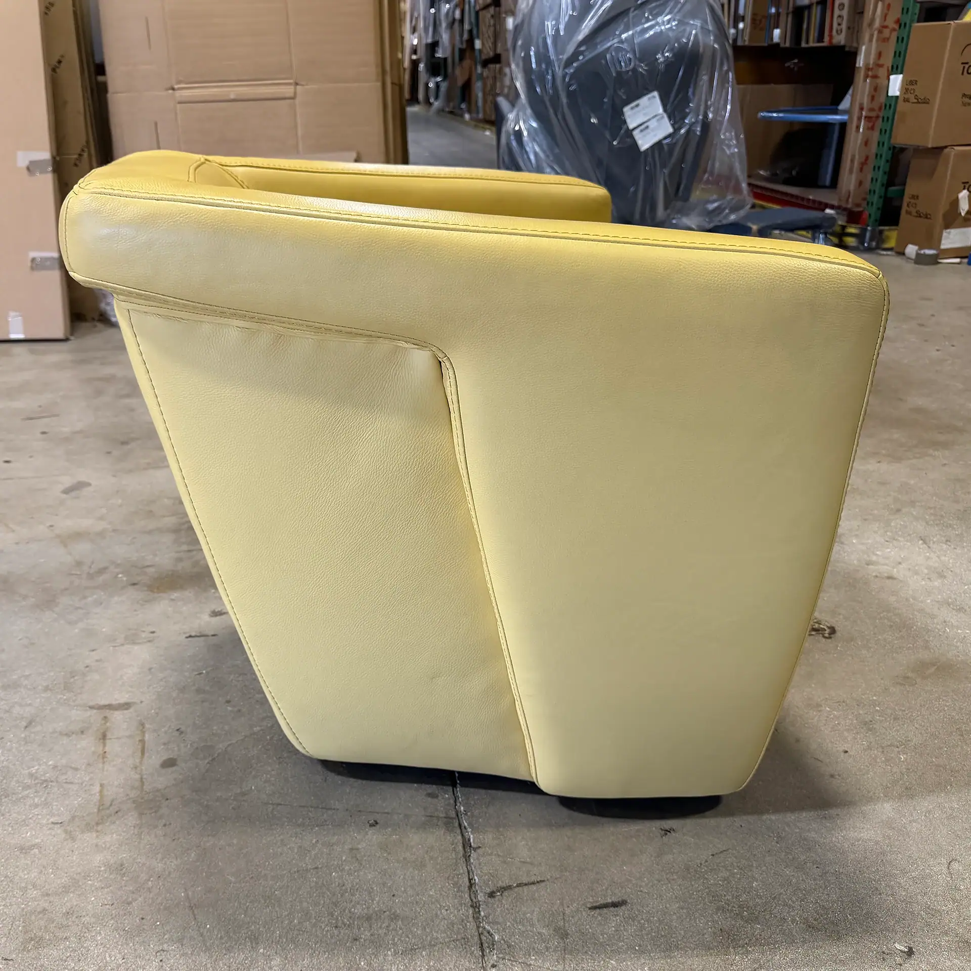 Yellow leather armchair with modern design in warehouse setting.