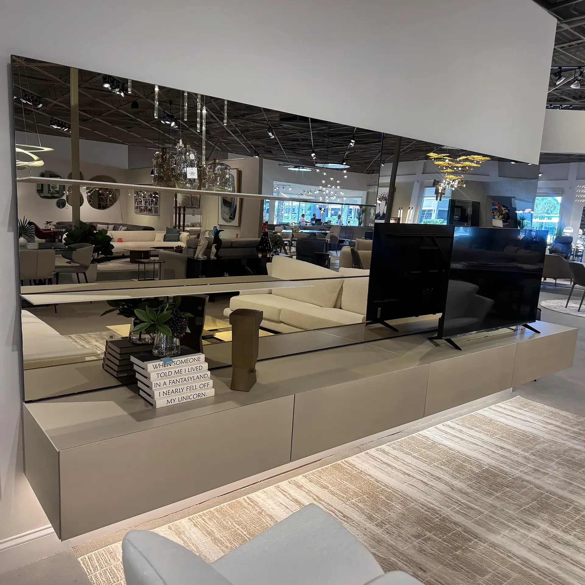 Contemporary wall unit with TV and storage in a furniture showroom.