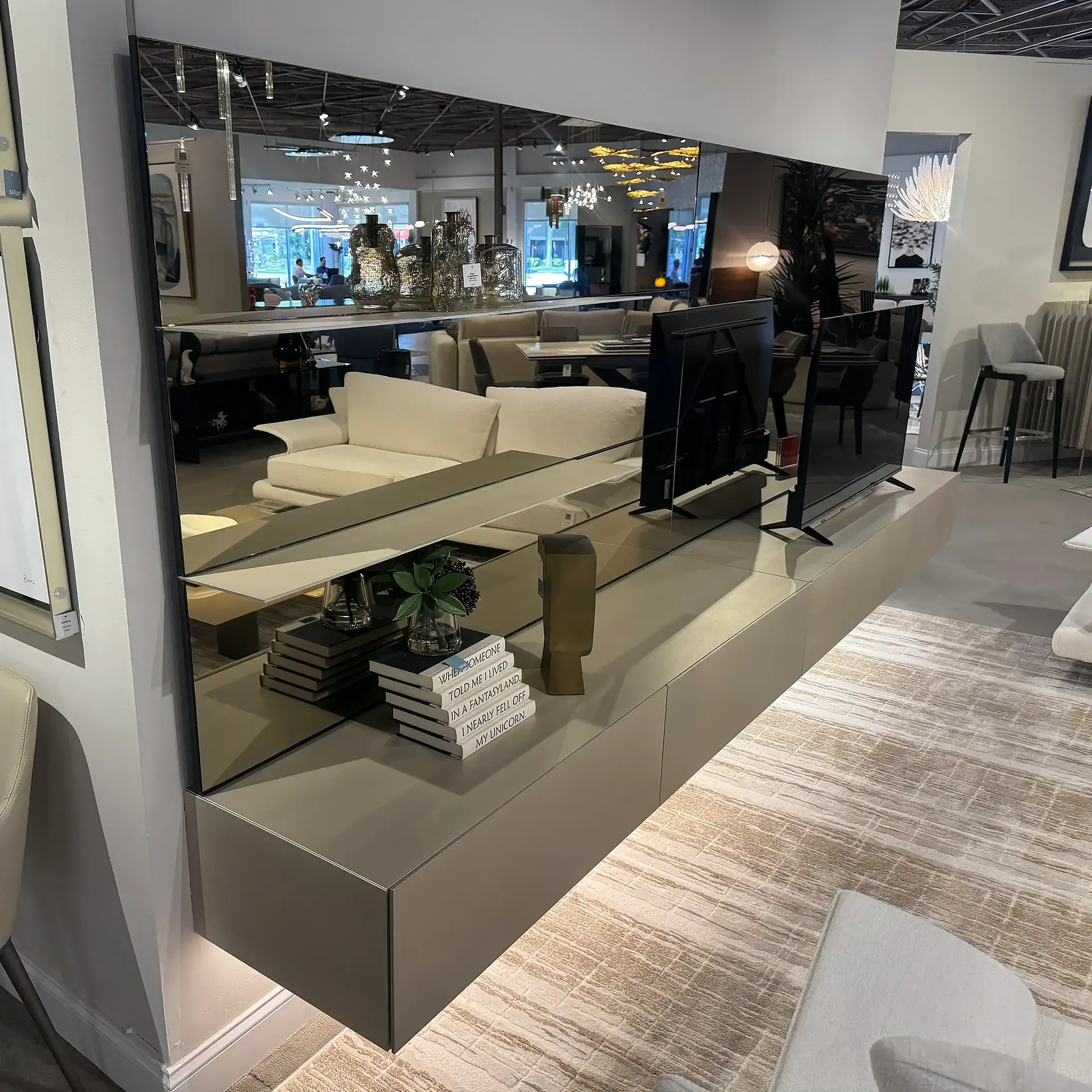 Contemporary wall unit with TV and storage in furniture showroom.