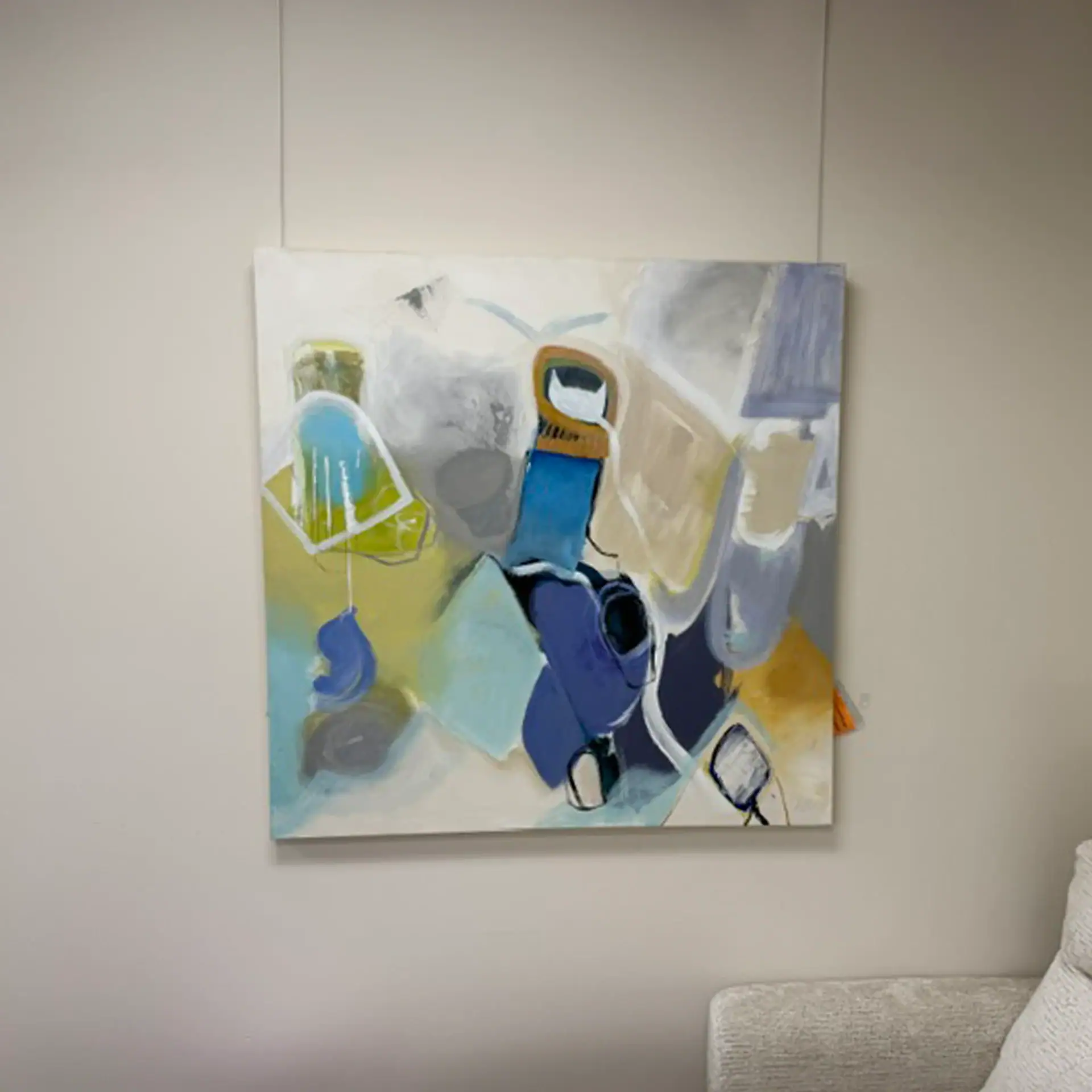 Abstract wall art with blue, yellow, and gray tones at Sklar Furnishings.