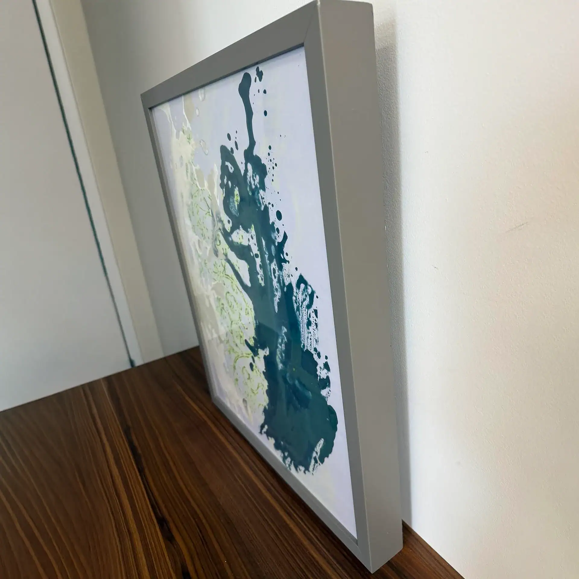 Modern abstract art framed print with blue and green splashes, wall decor for contemporary interiors.