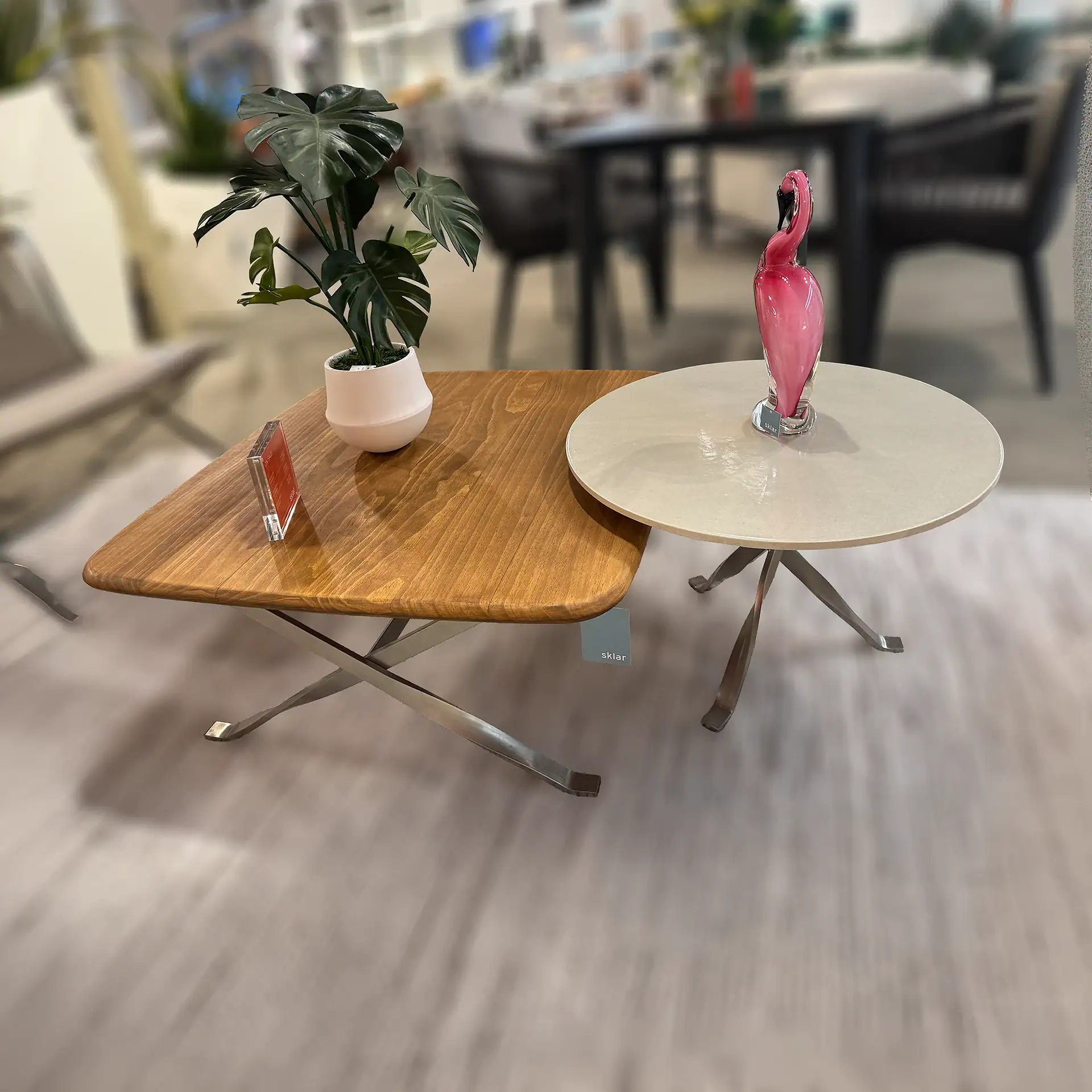 Modern coffee tables with wooden and white finishes, decorative flamingo, and potted plant.