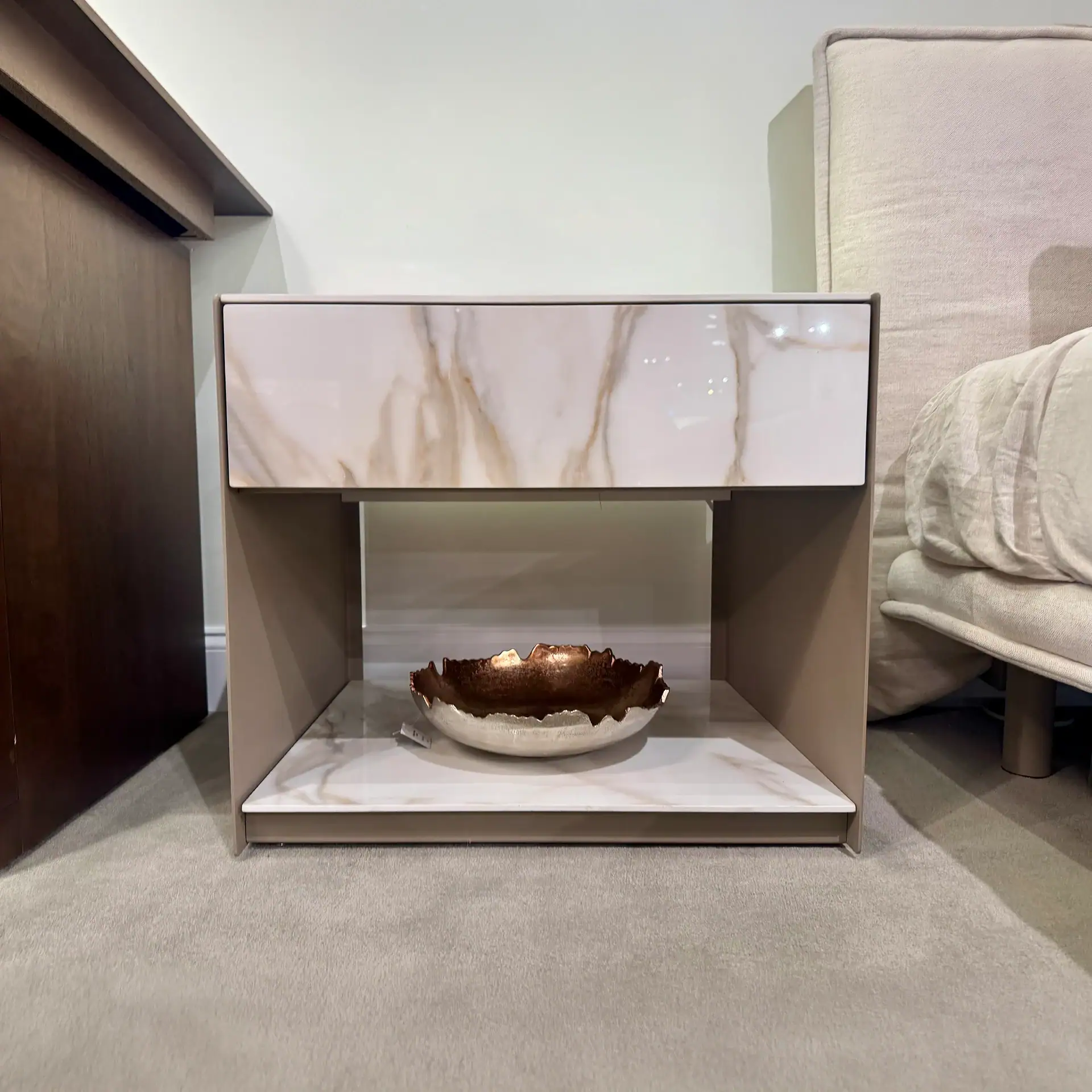 Modern nightstand with marble top and drawer, stylish bedroom furniture piece.