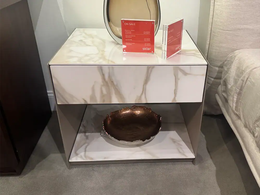 Modern nightstand with marble top and open shelf, stylish bedroom furniture.