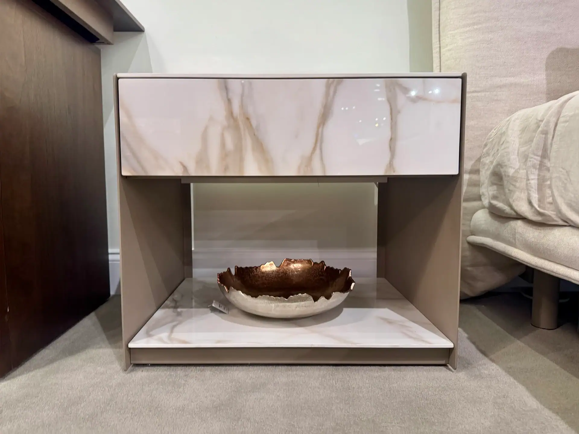 Modern nightstand with marble top and drawer, stylish bedroom furniture piece.